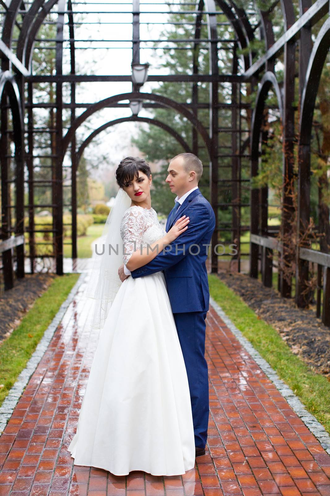 Couple standing in the rain on the wedding day