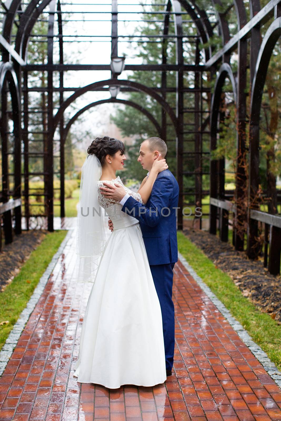 Couple standing in the rain on the wedding day by lanser314