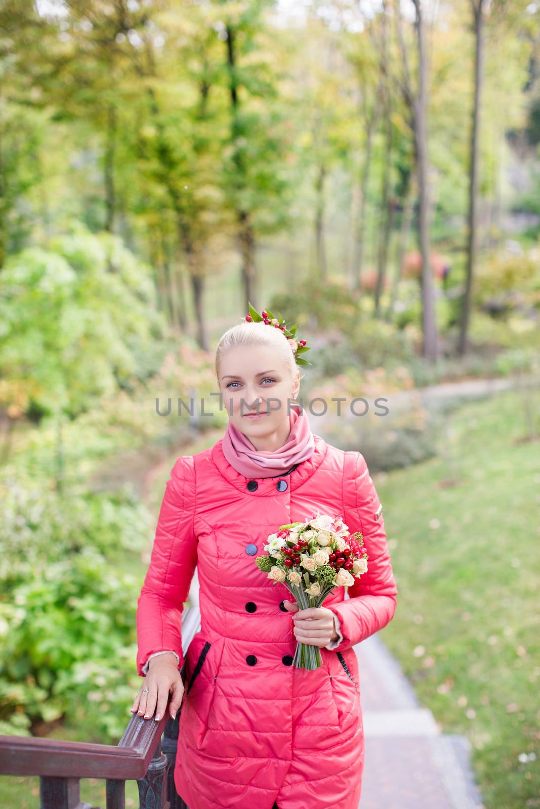 The blonde in a red jacket with a bouquet of flowers