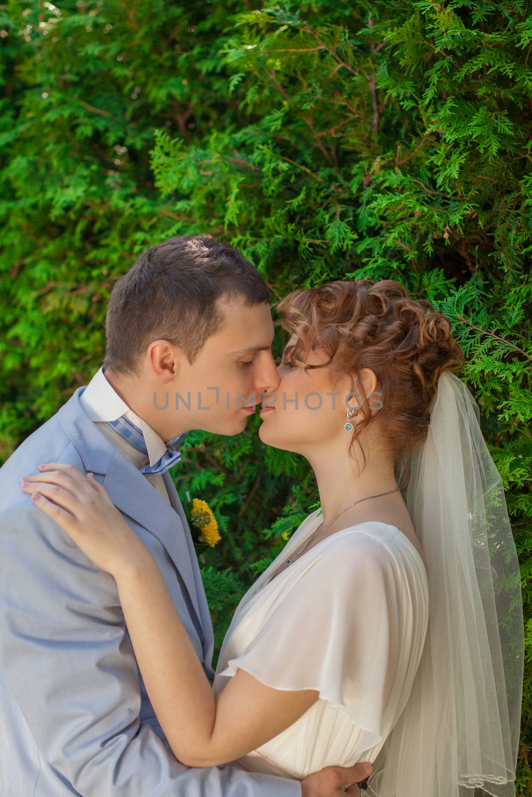 Romantic kiss happy bride and groom on wedding day