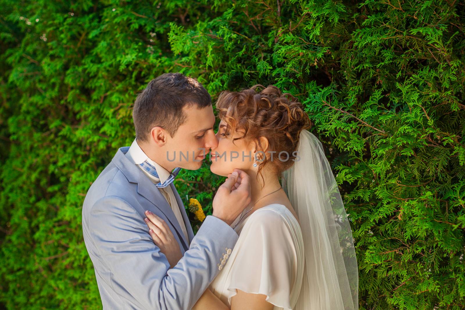 Romantic kiss happy bride and groom on wedding day