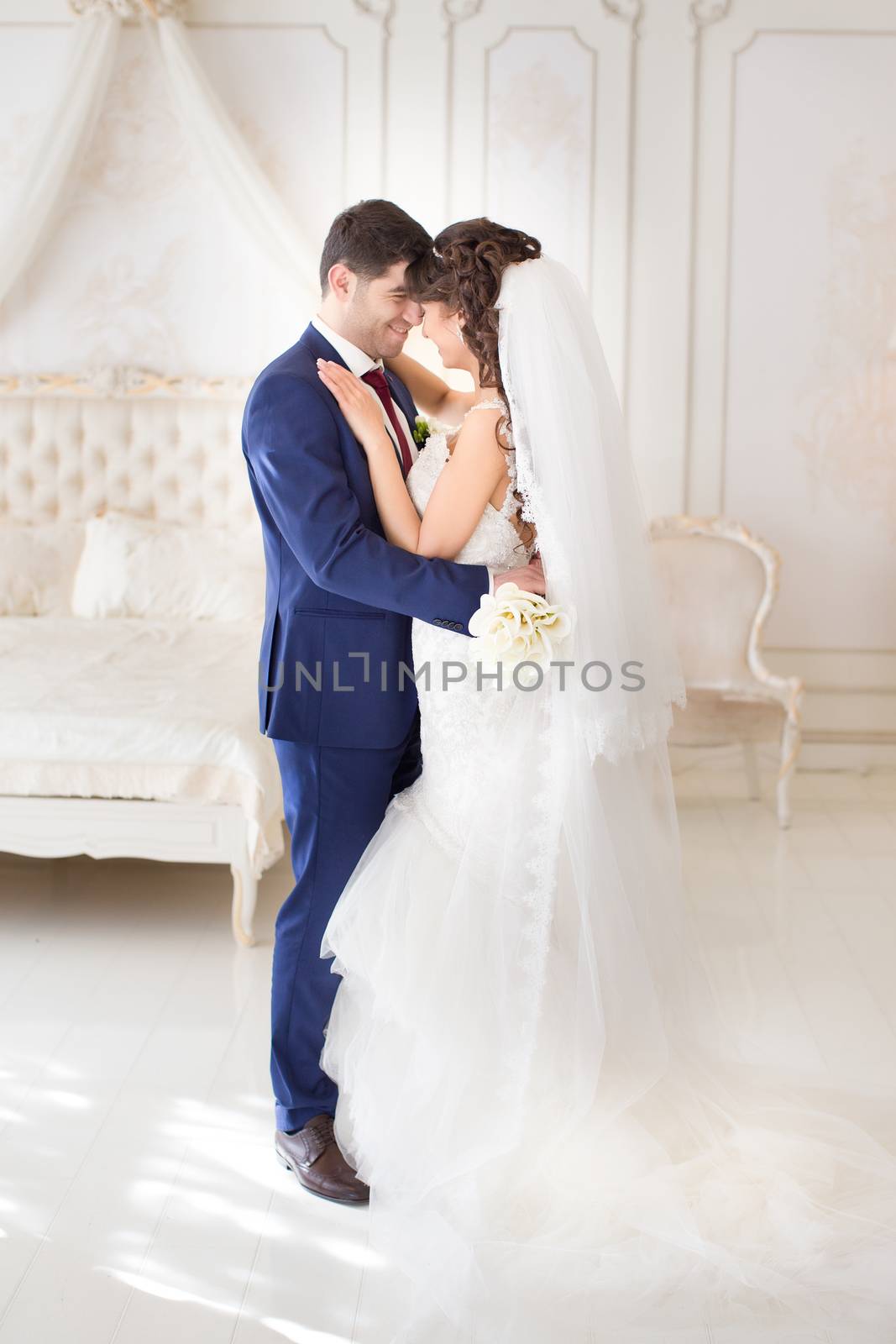 Stylish newlyweds posing for the camera in the apartment