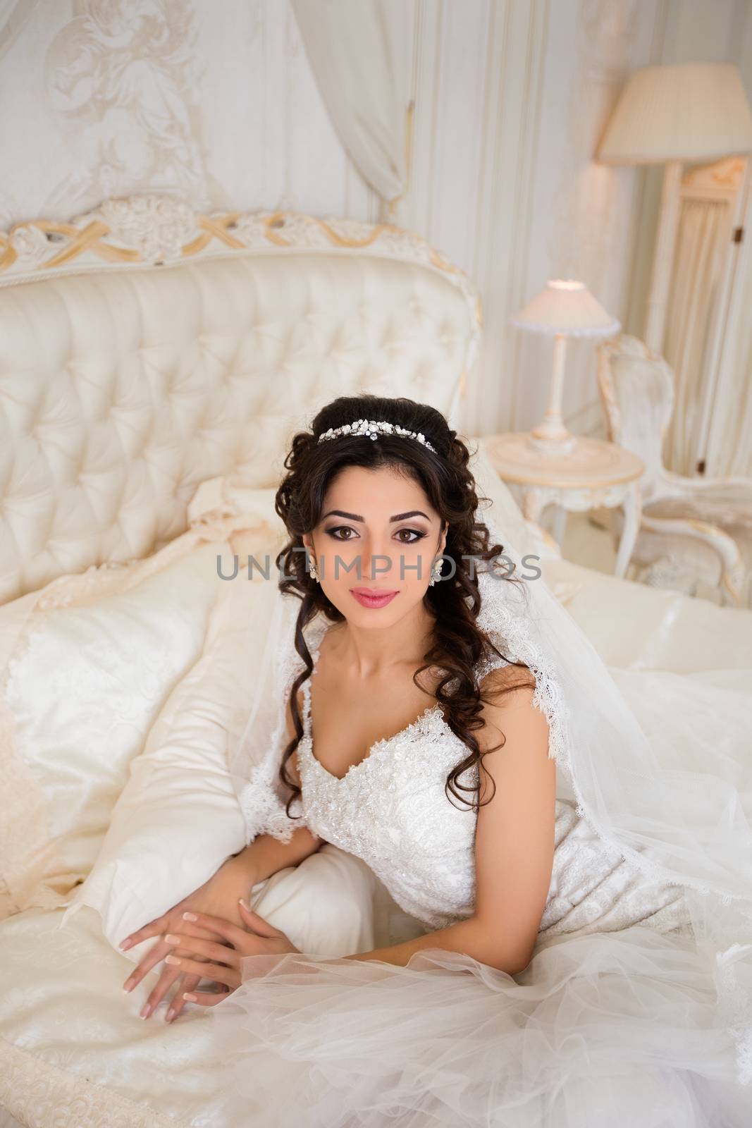 beautiful brunette bride in a luxurious wedding dress posing in interior