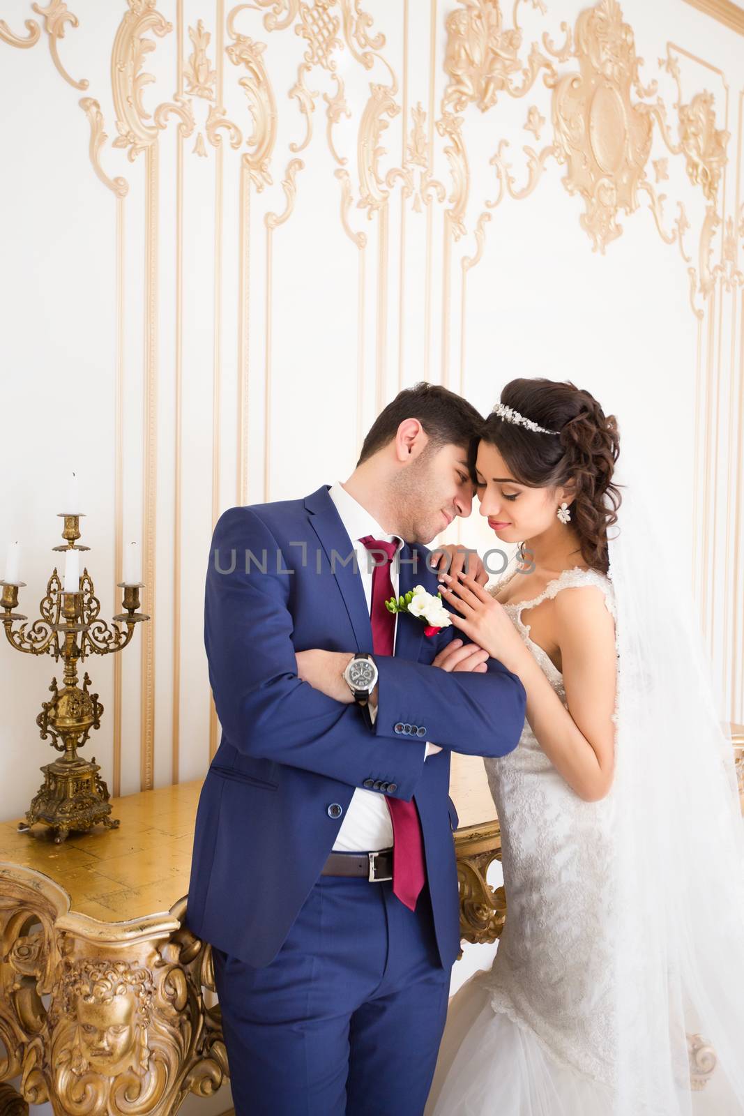 Stylish newlyweds posing for the camera in the apartment