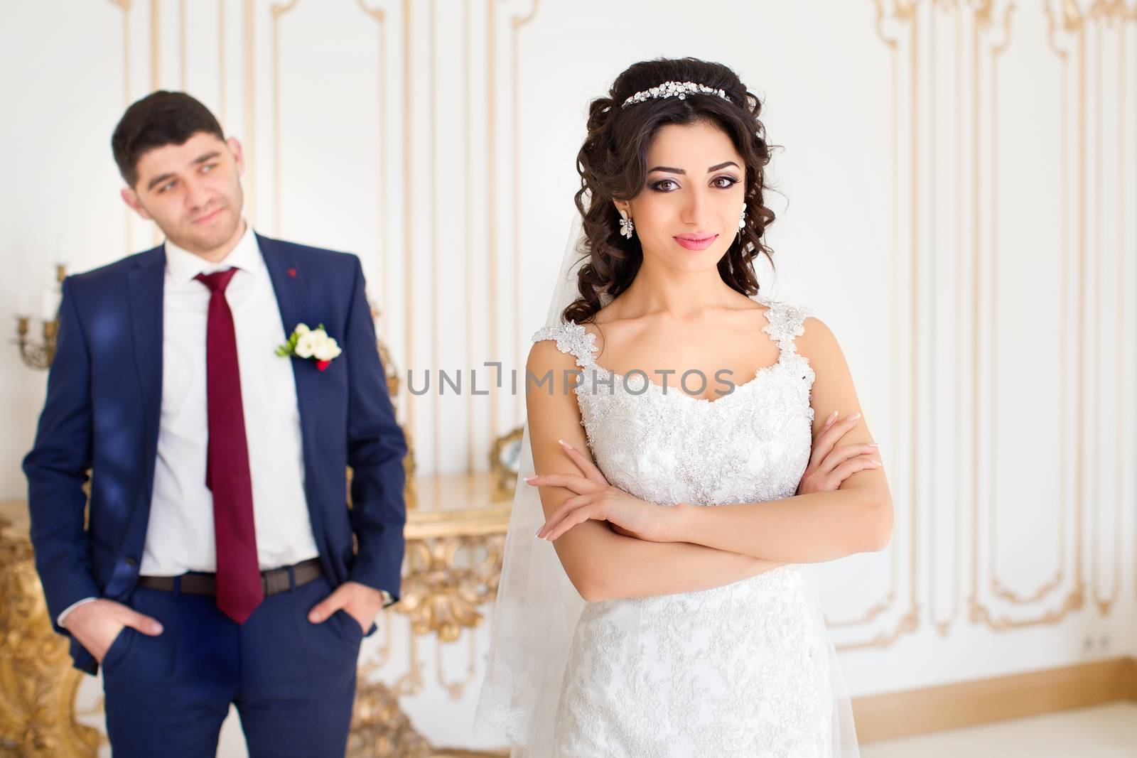 Stylish newlyweds posing for the camera in the apartment