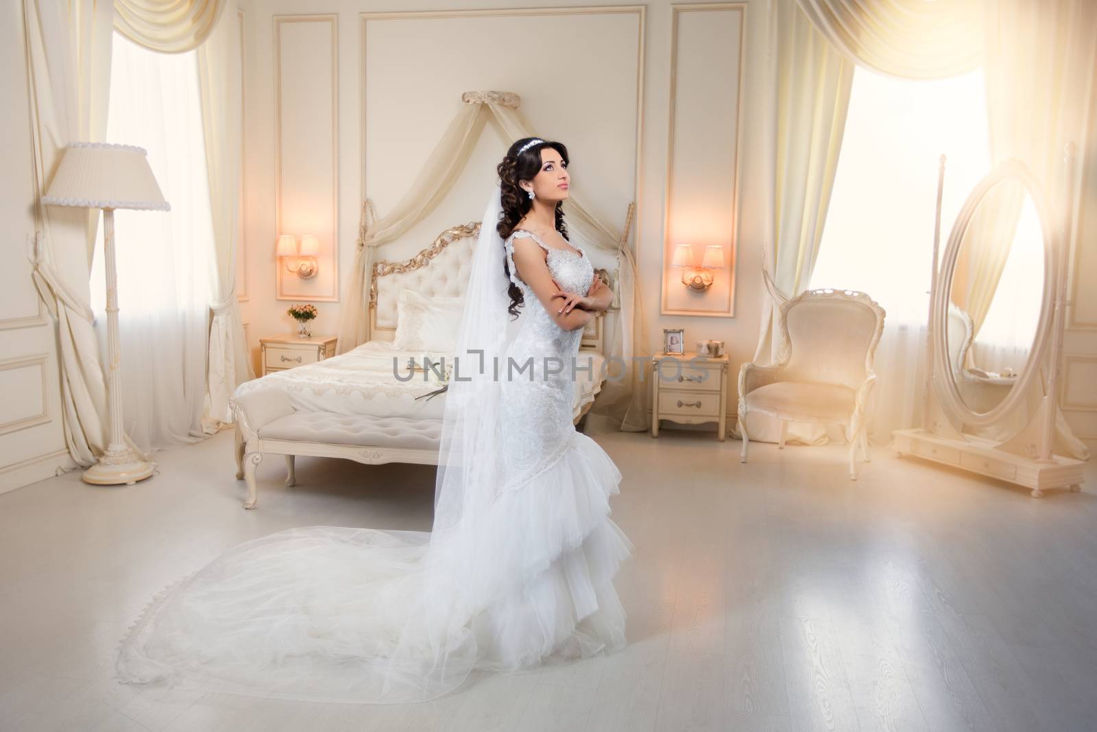 beautiful brunette bride in a luxurious wedding dress posing in interior