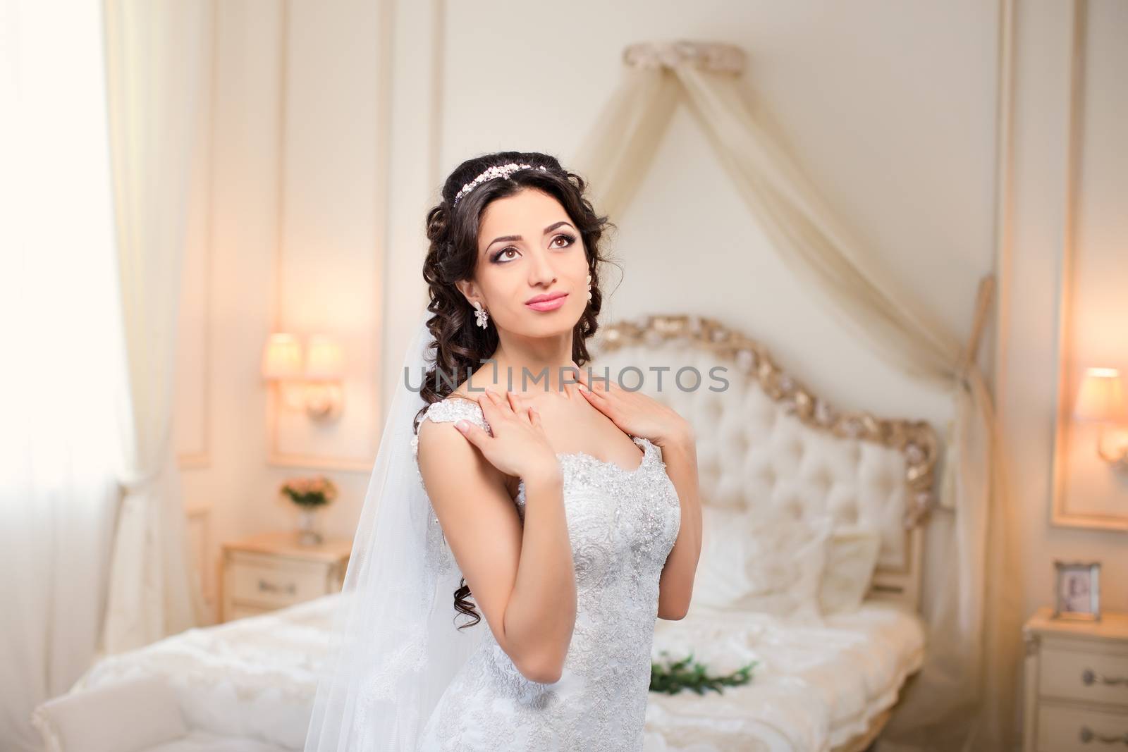 beautiful brunette bride in a luxurious wedding dress posing in interior