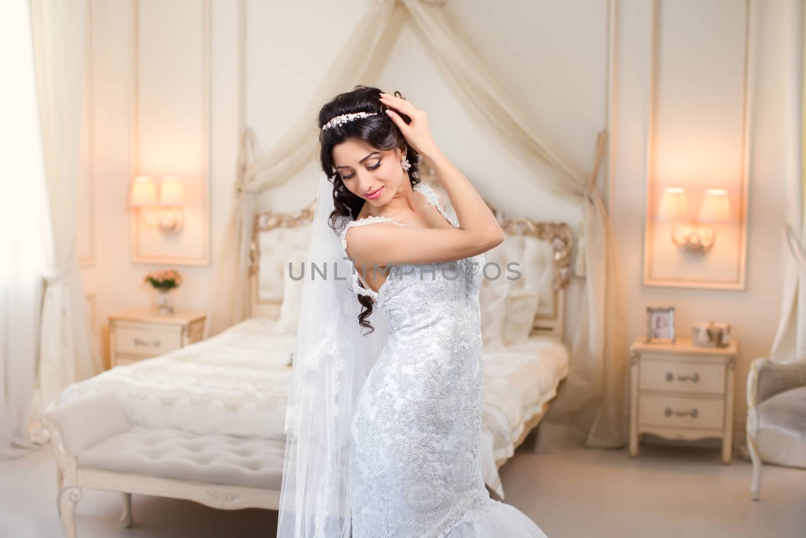 beautiful brunette bride in a luxurious wedding dress posing in interior