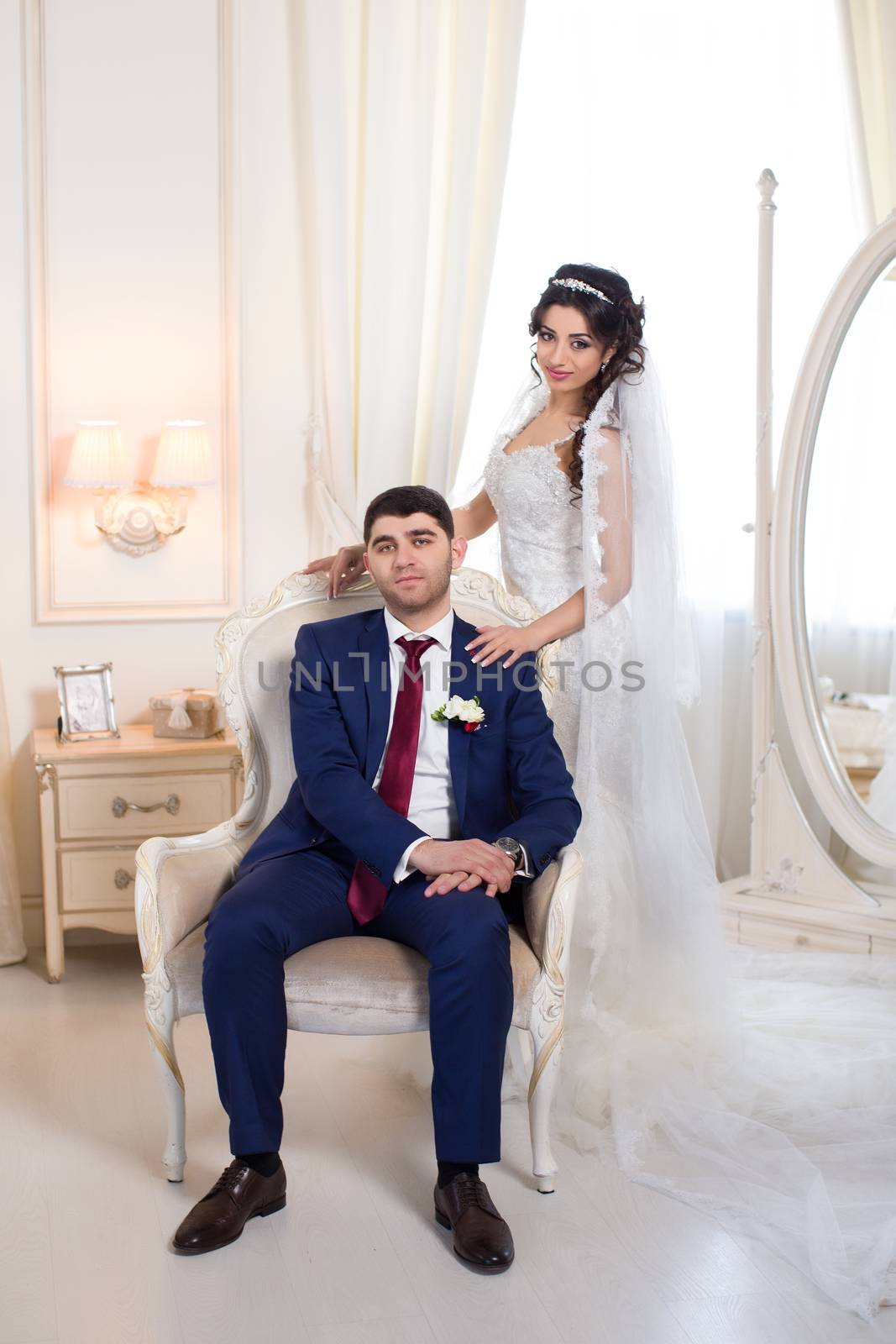 Stylish newlyweds posing for the camera in the apartment