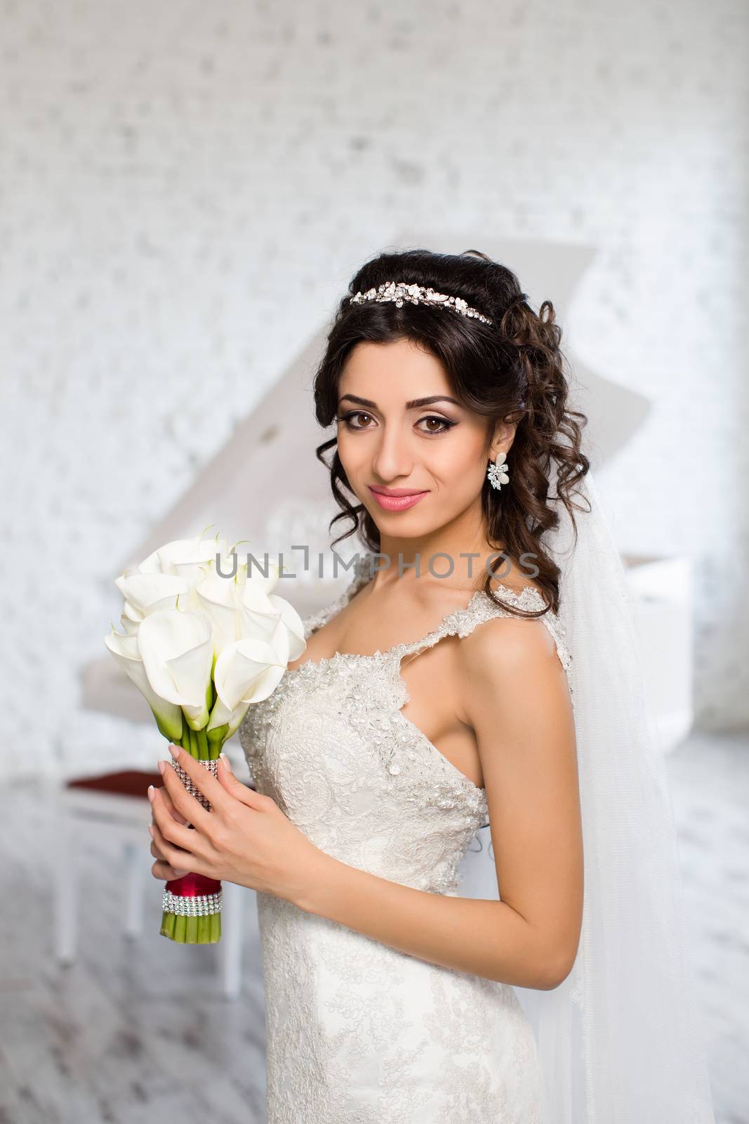 beautiful brunette bride in a luxurious wedding dress posing in interior