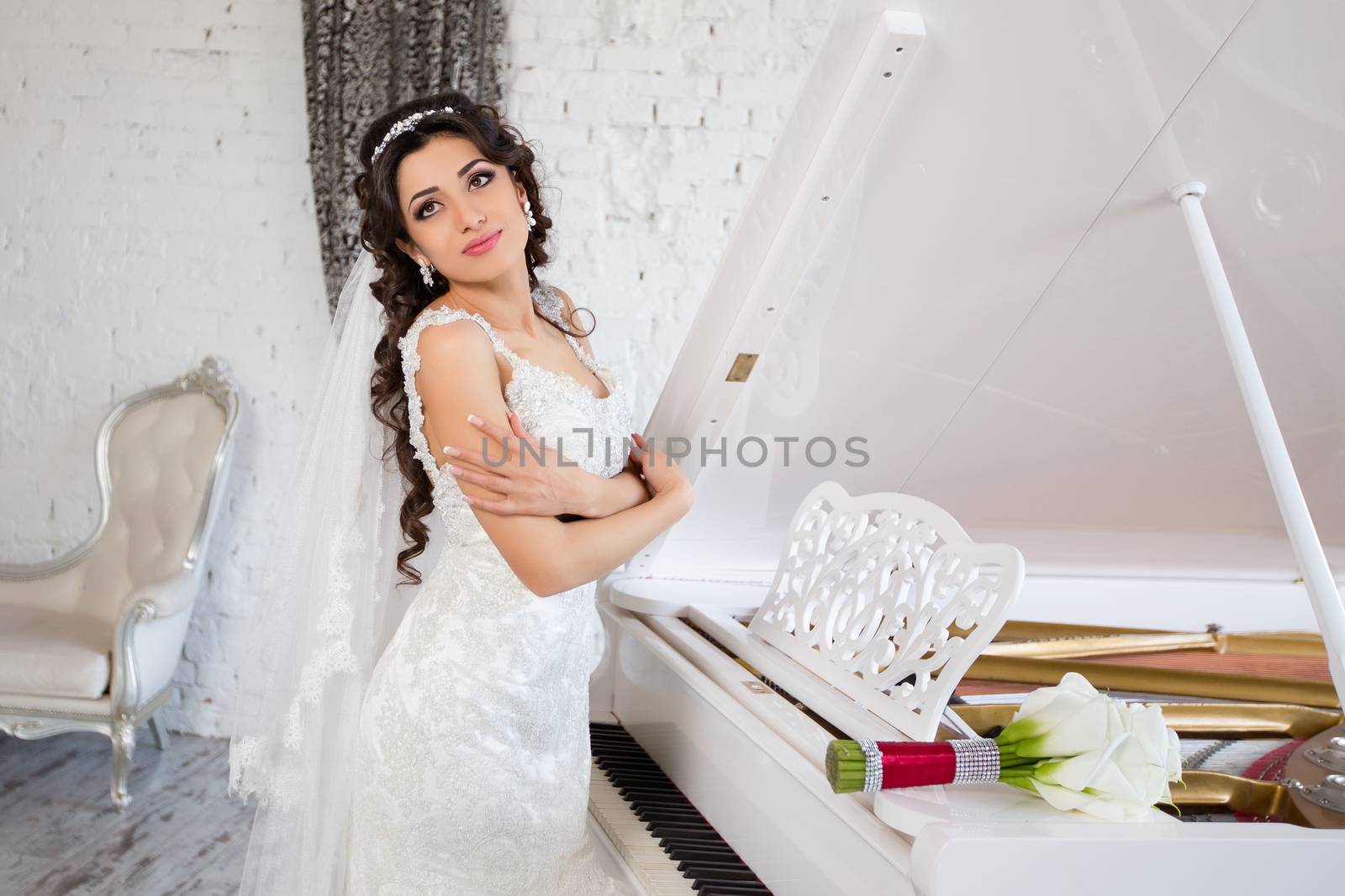 beautiful brunette bride in a luxurious wedding dress posing in interior
