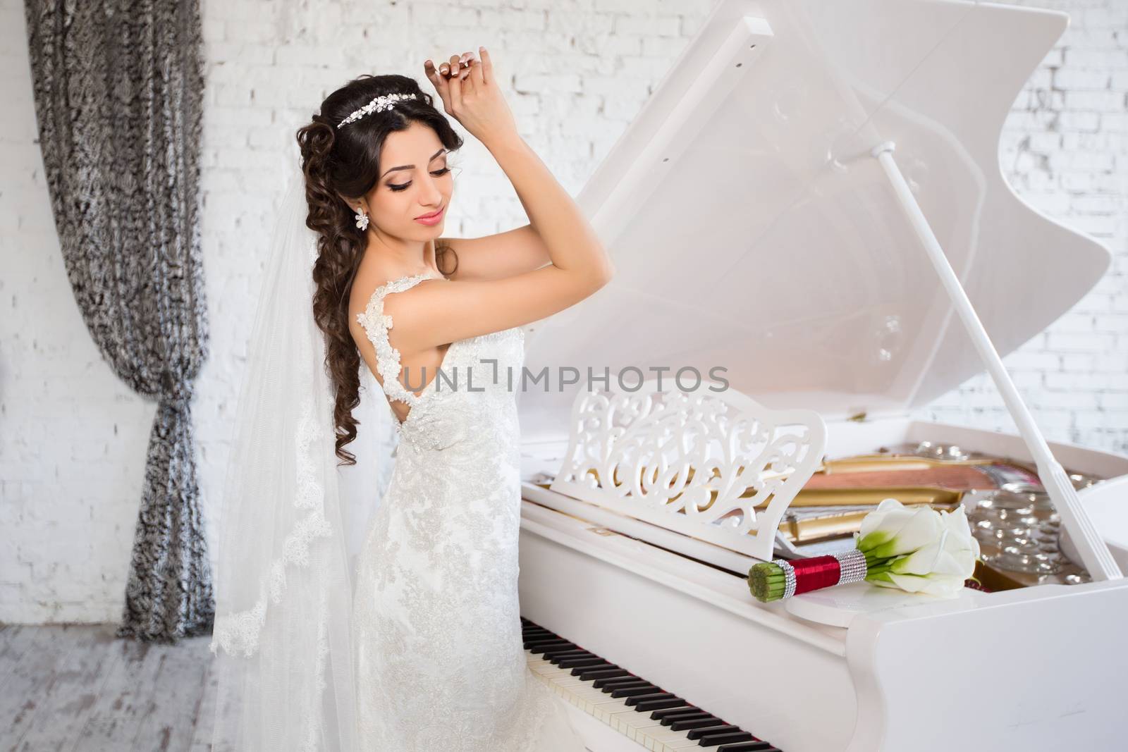 beautiful brunette bride in a luxurious wedding dress posing in interior
