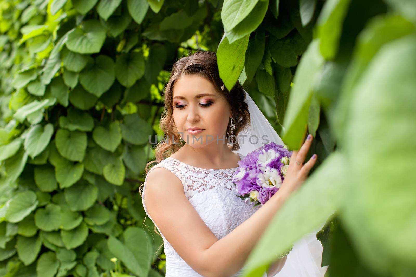 The bride with a bouquet of lilac with wreath