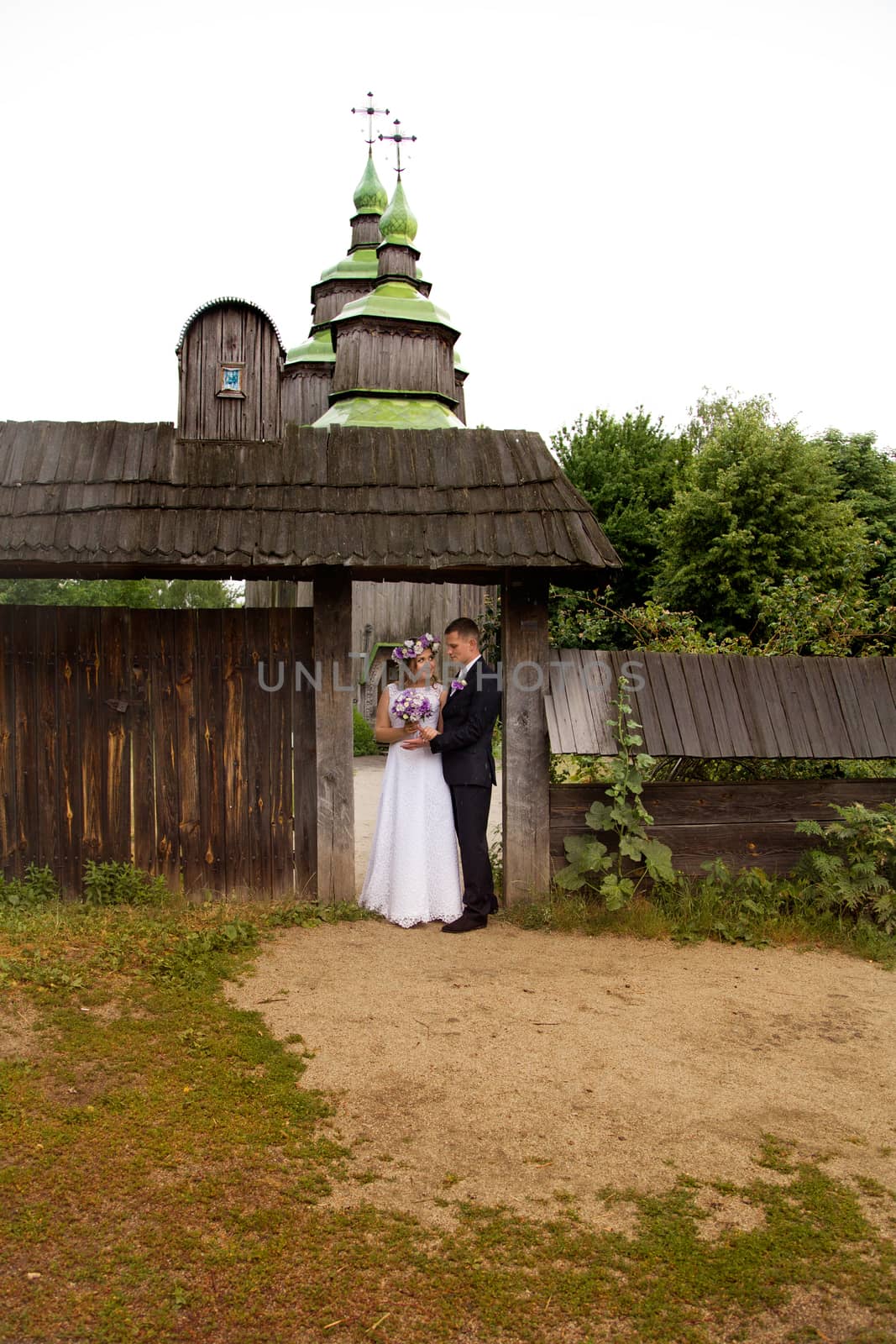 groom gently embraces the bride on walk in the country by lanser314