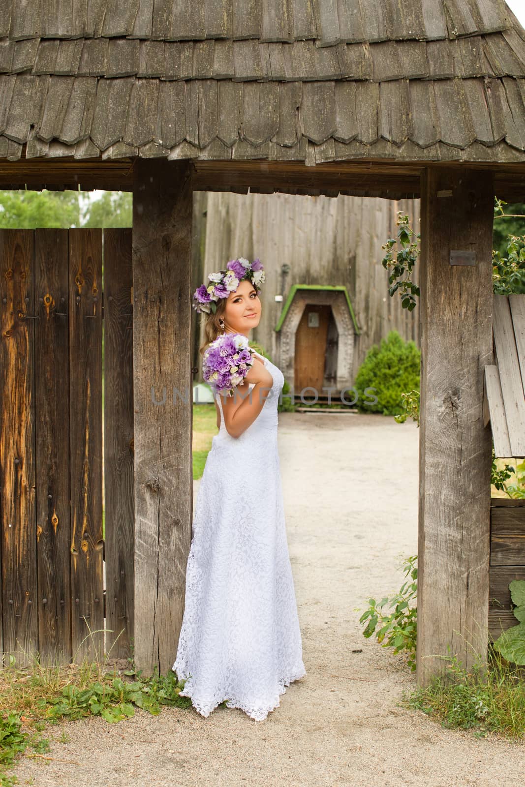 The bride with a bouquet of lilac with wreath