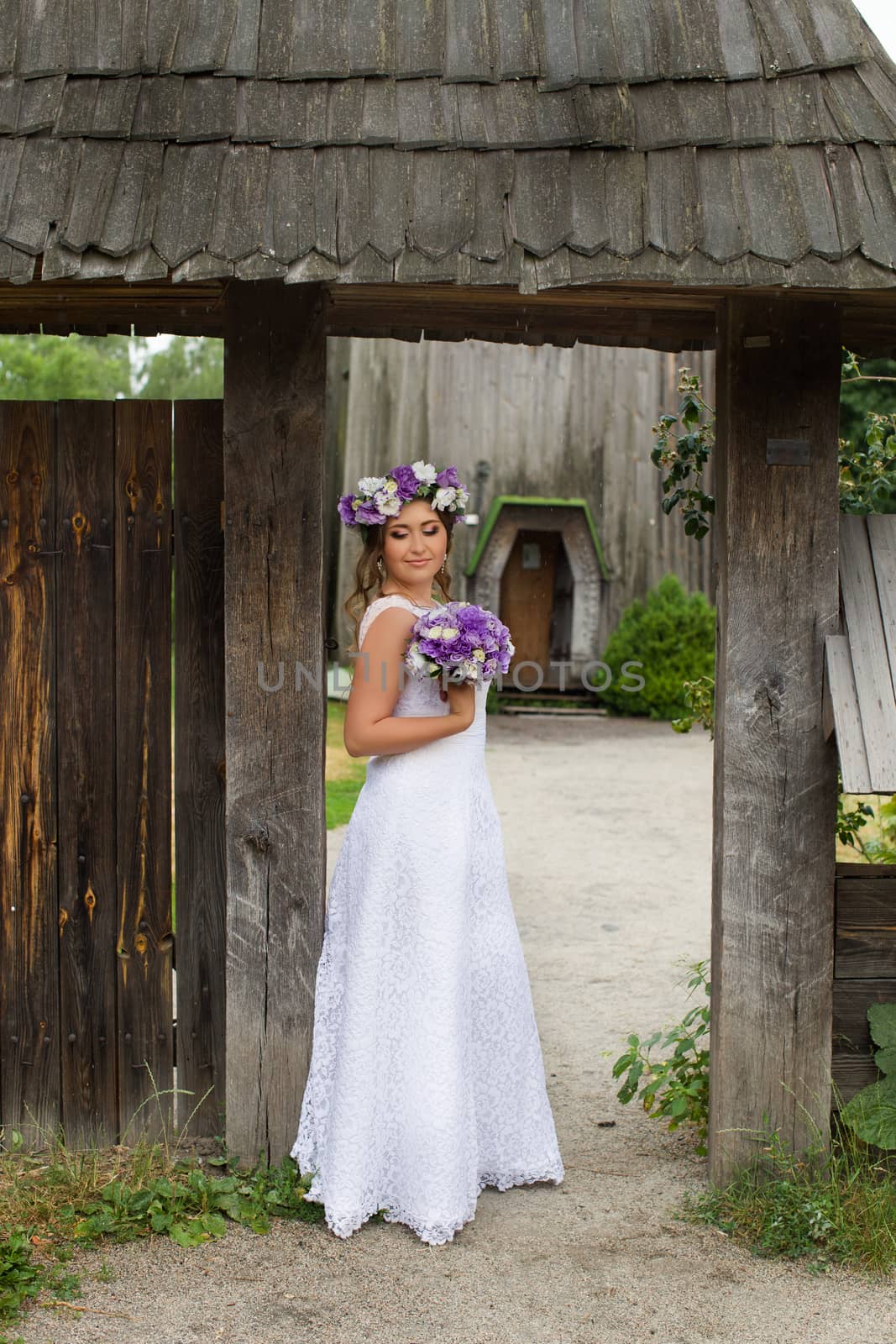 The bride with a bouquet of lilac with wreath