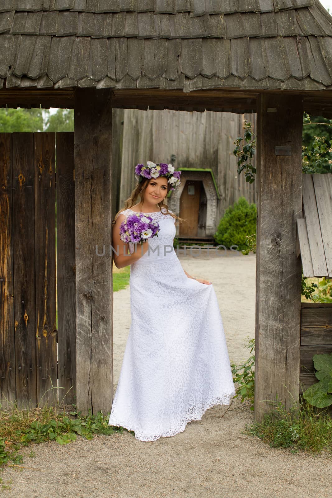 The bride with a bouquet of lilac with wreath