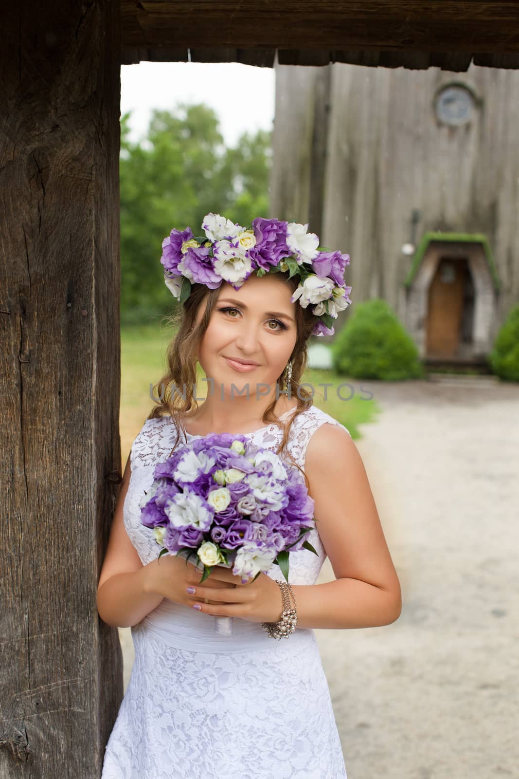 The bride with a bouquet of lilac with wreath
