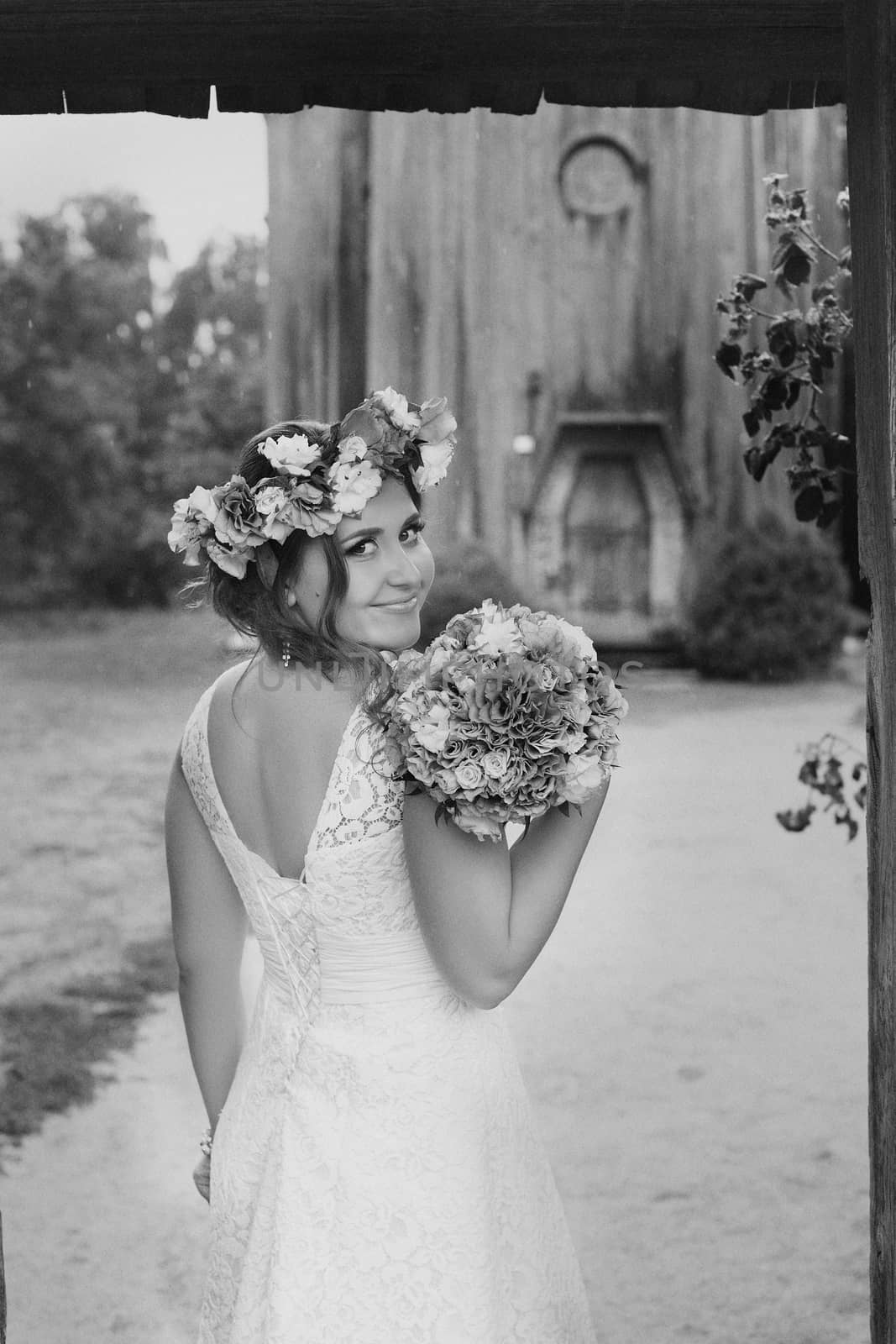 The bride with a bouquet of lilac with wreath