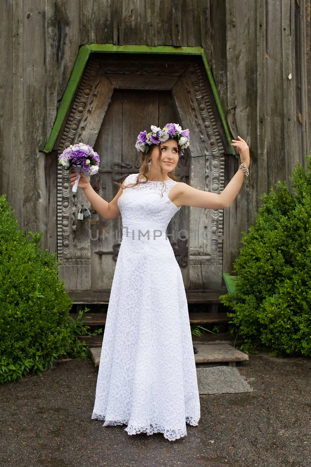 The bride with a bouquet of lilac with wreath