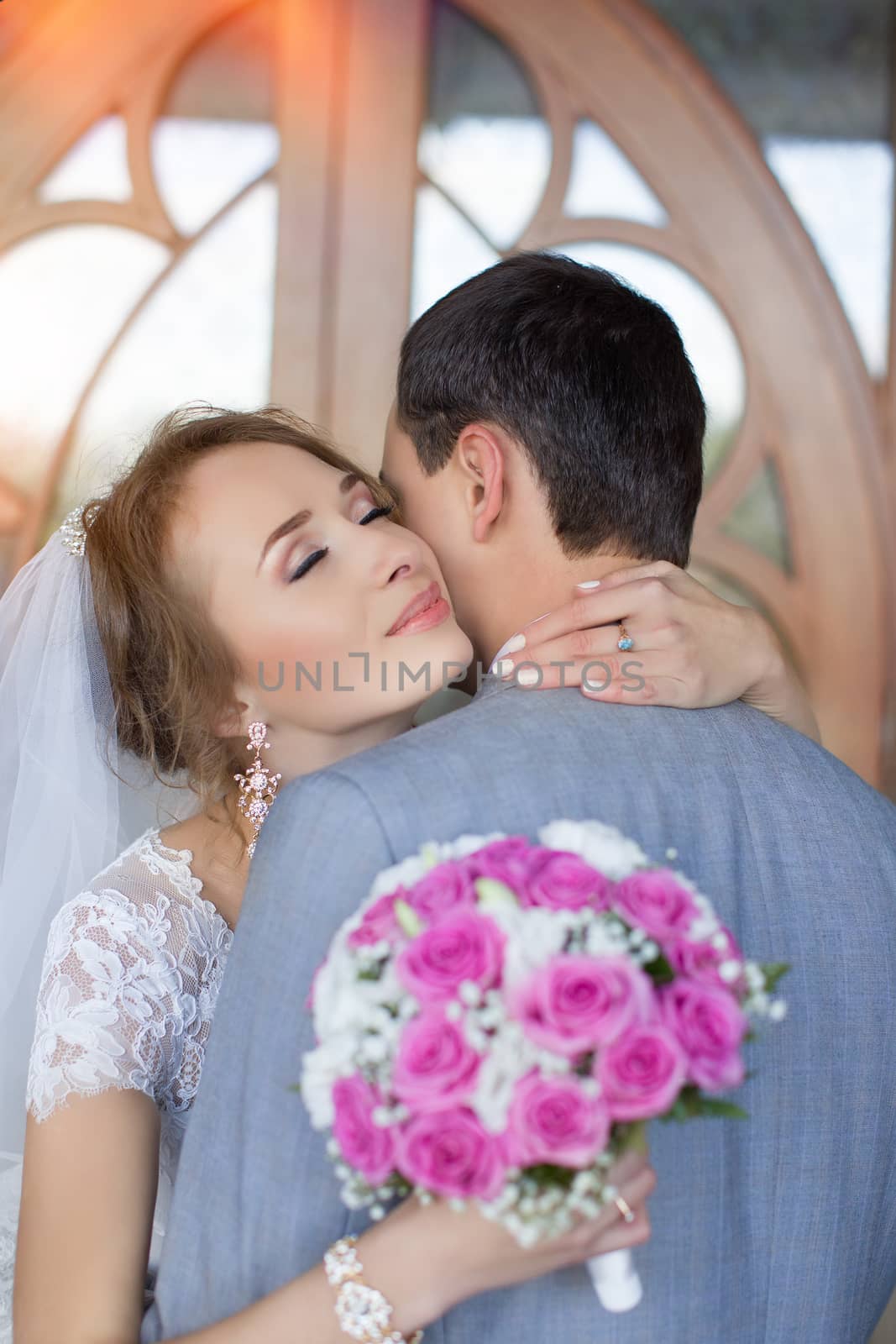 Bride and groom at wedding Day walking Outdoors on spring nature. Bridal couple, Happy Newlywed woman and man embracing in green park. Loving wedding couple outdoor. Bride and groom