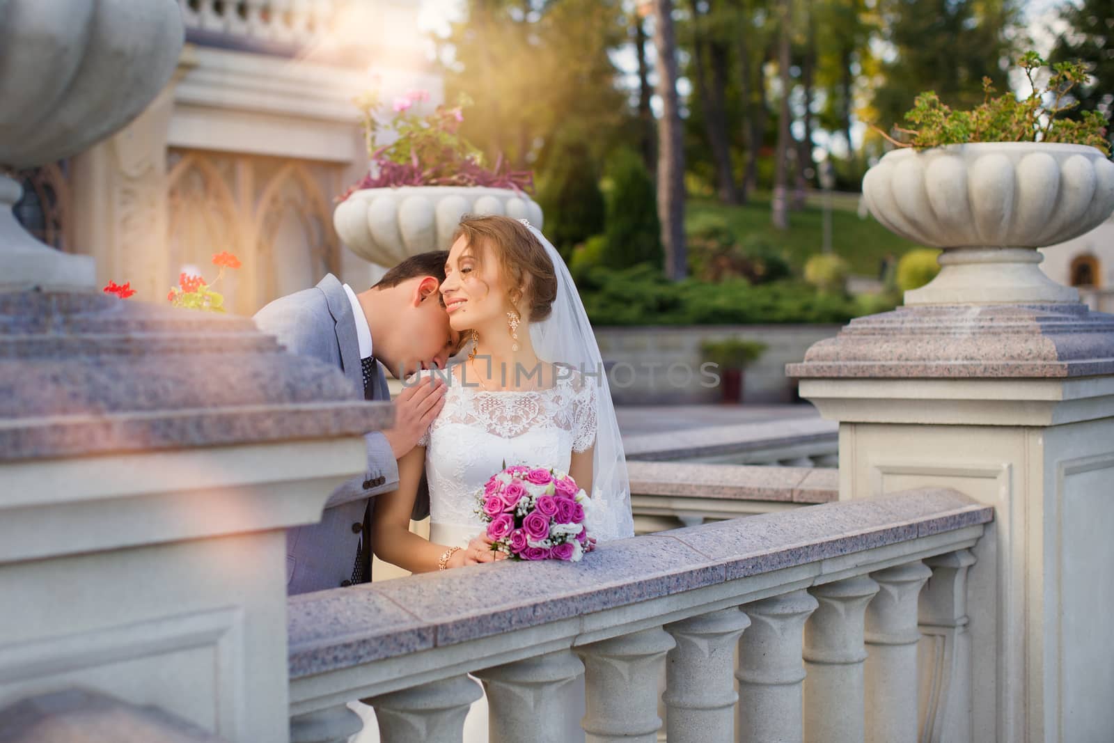 Bride and groom at wedding Day walking Outdoors on spring nature. Bridal couple, Happy Newlywed woman and man embracing in green park. Loving wedding couple outdoor. Bride and groom