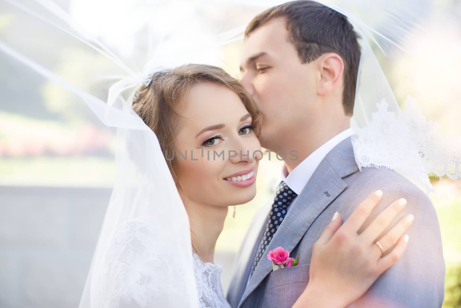 Bride and groom at wedding Day walking Outdoors on spring nature. Bridal couple, Happy Newlywed woman and man embracing in green park. Loving wedding couple outdoor. Bride and groom