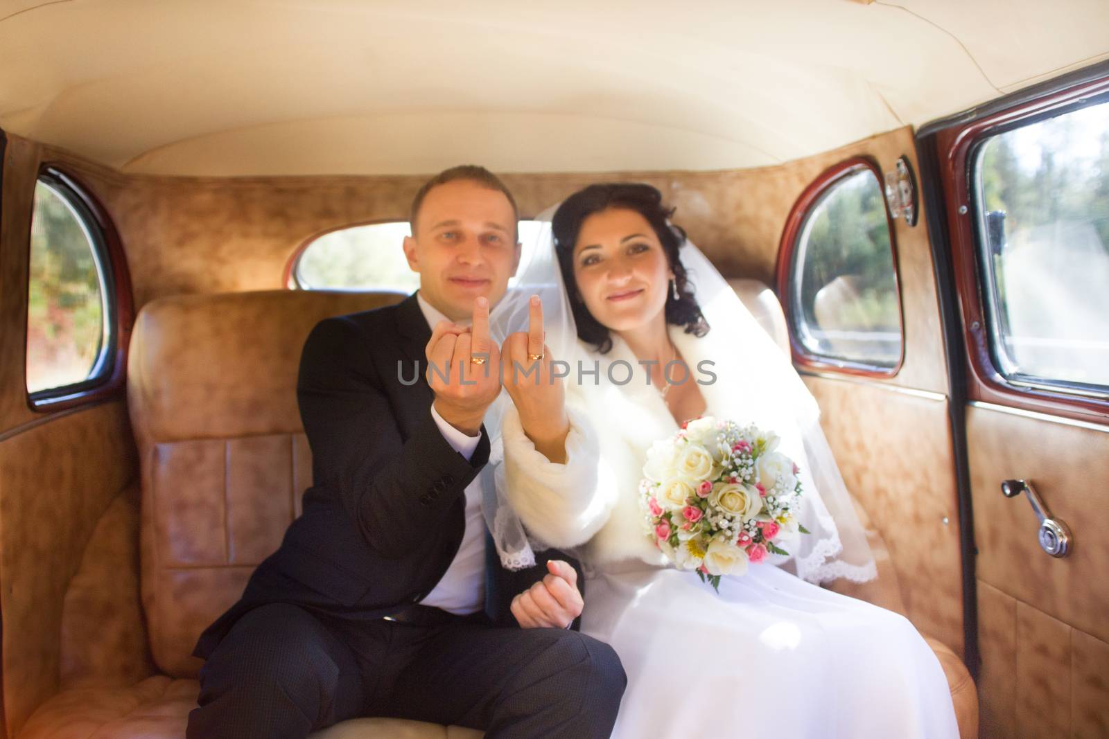 Young couple sitting  inside retro car by lanser314