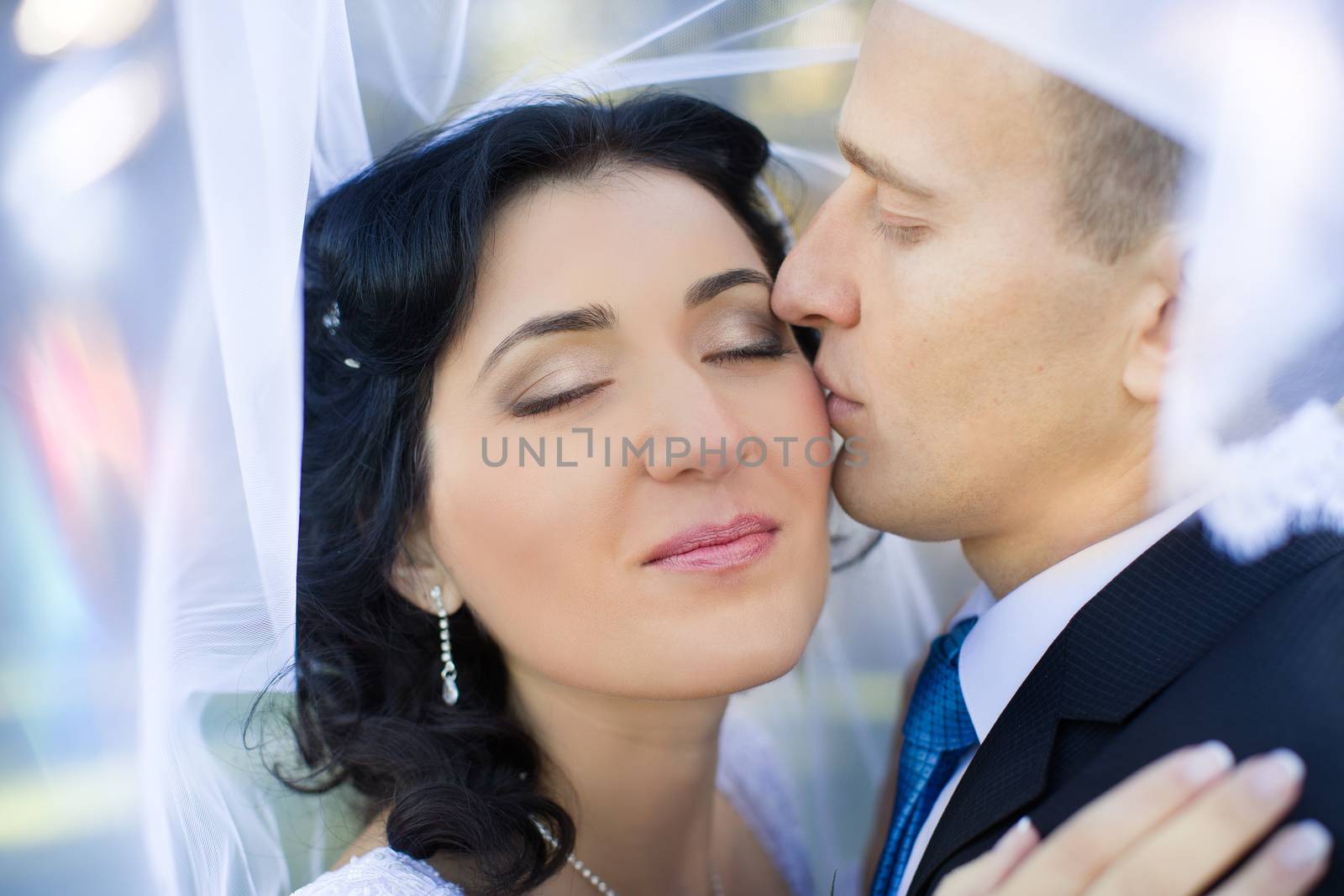 the groom gently embraces and kisses the bride by lanser314