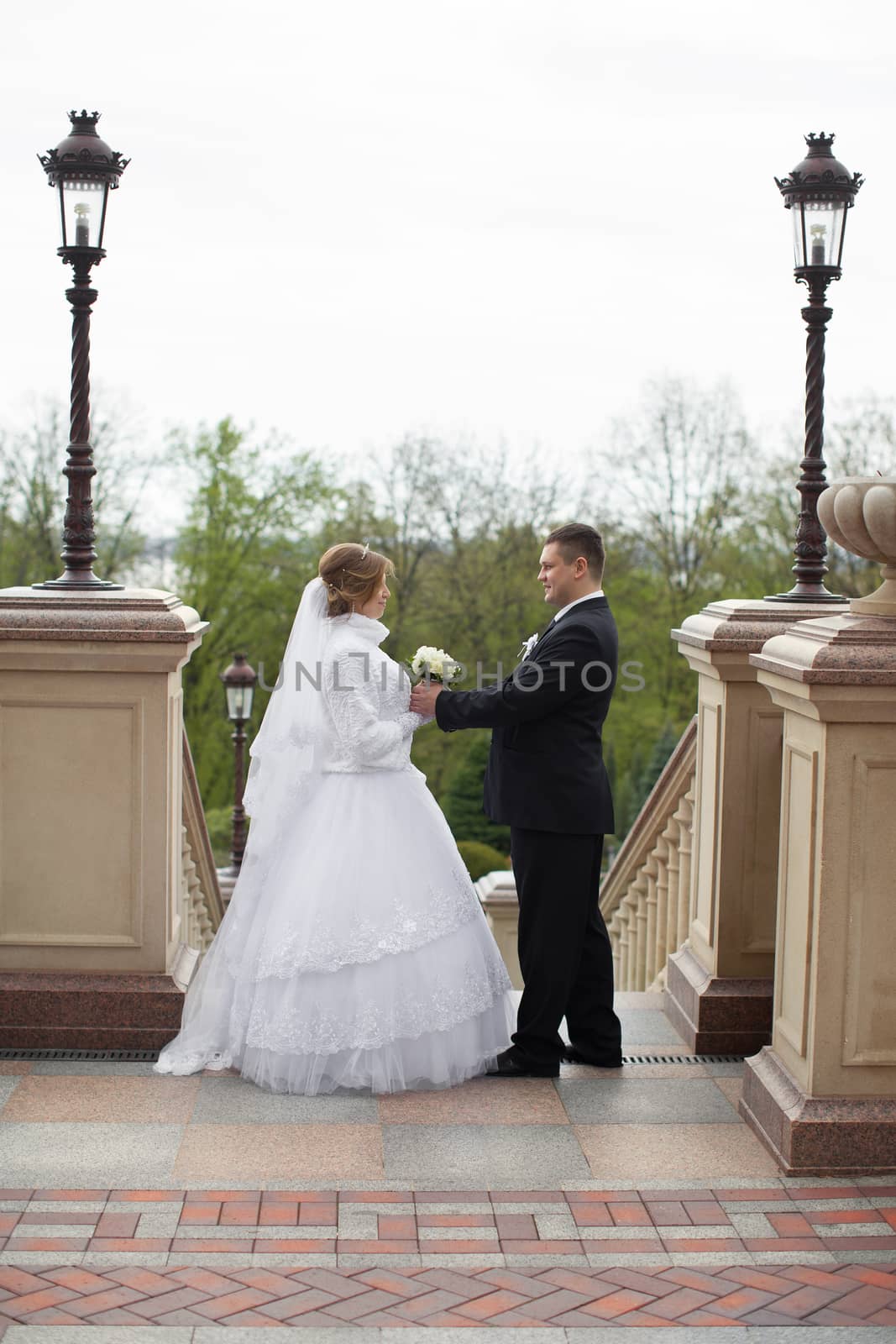 The bride to the groom leaned against the backdrop of a stone wall