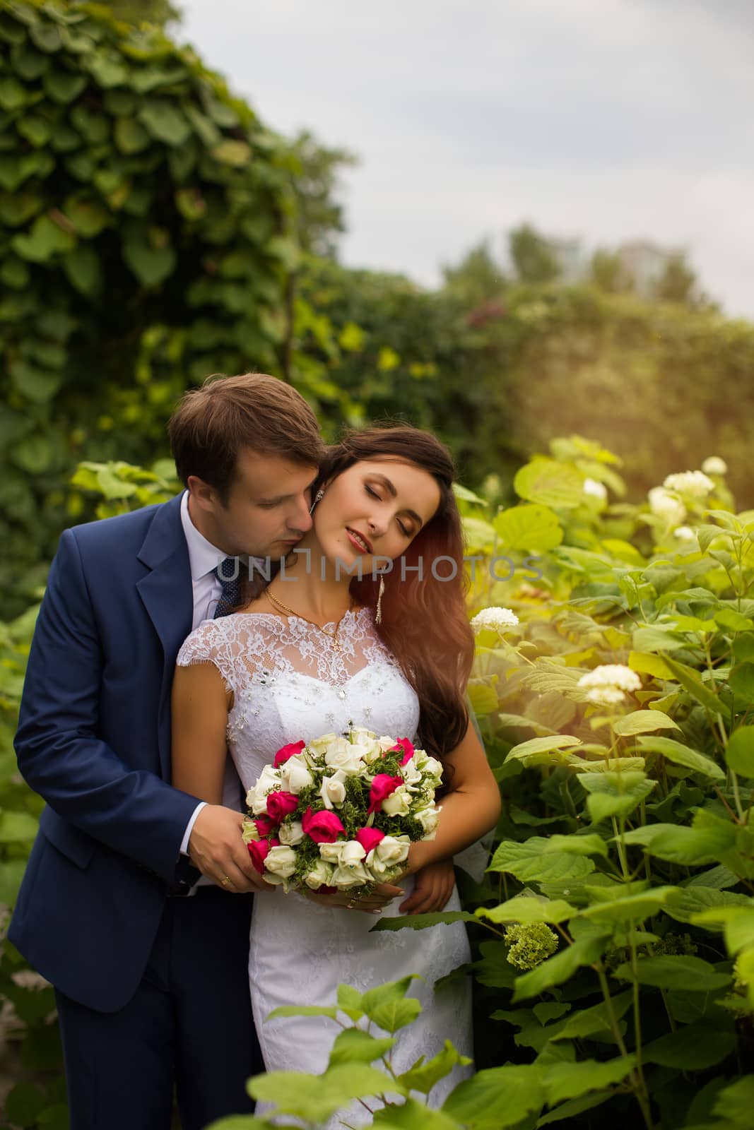 Newlyweds embracing in park by lanser314