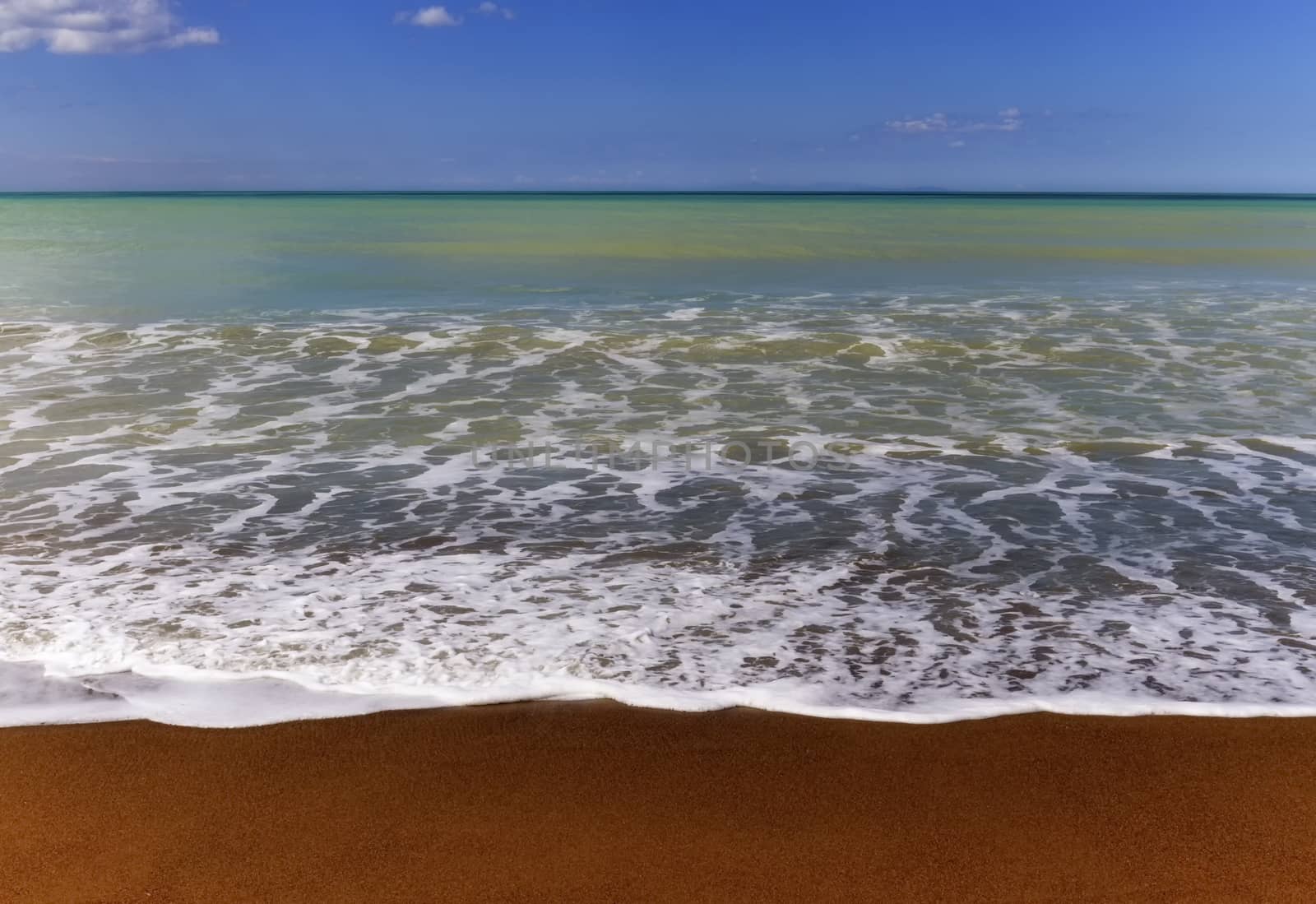 Sand, water wave and beautiful sky at the beach