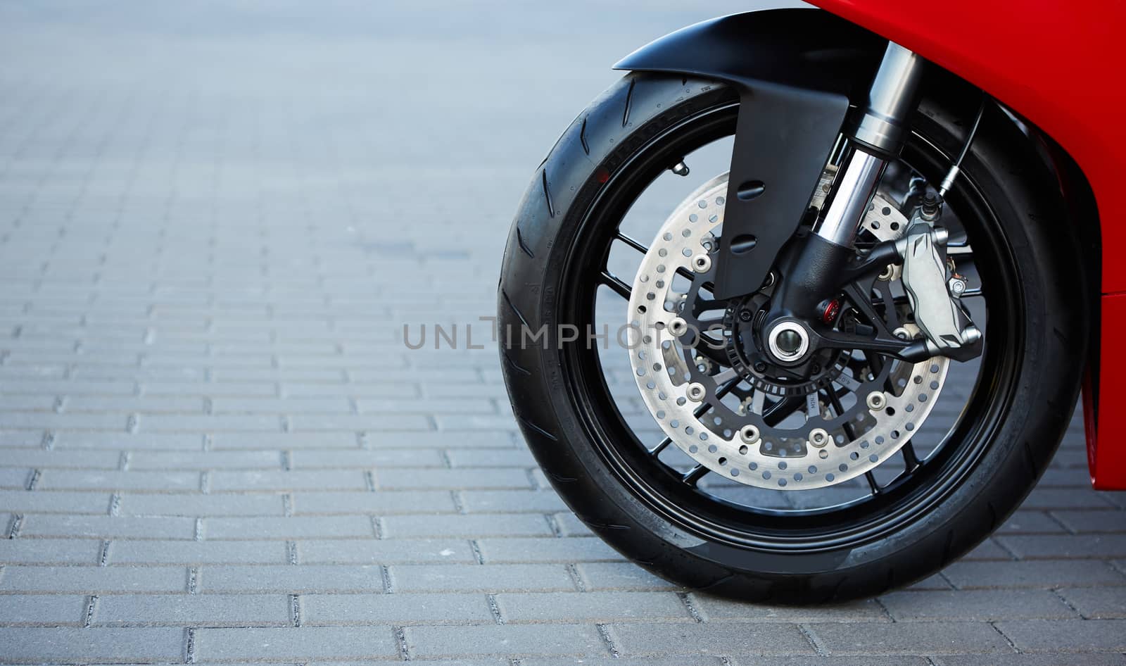 The Front motorcycle disk breaks and tire in close up