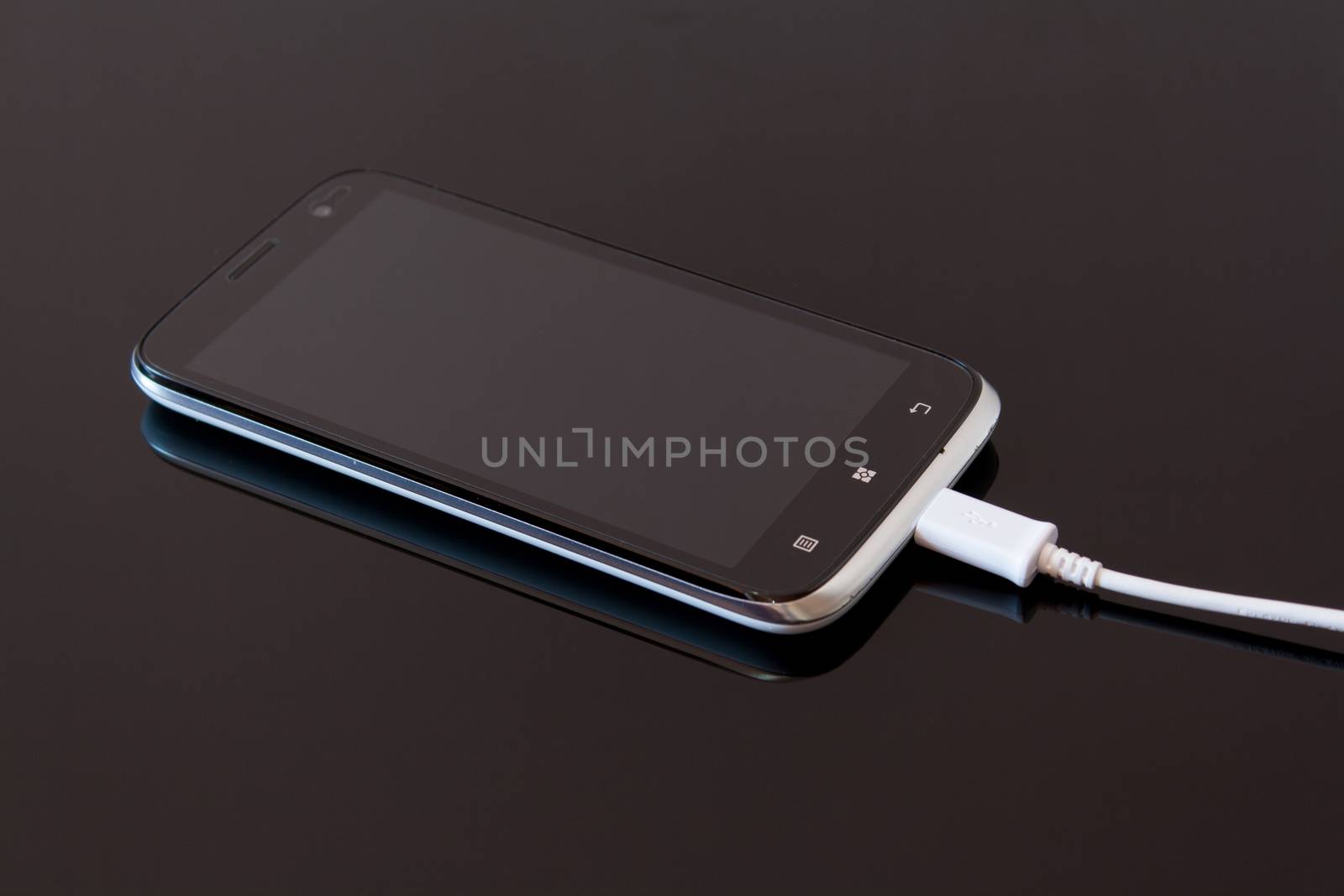 Black Smart Phone Charging with Cable on the Black Table