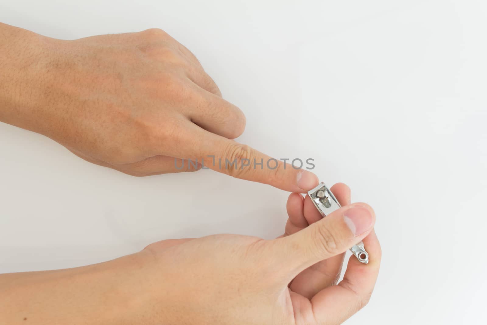 male hand cutting nails with nail clippers on isolate background