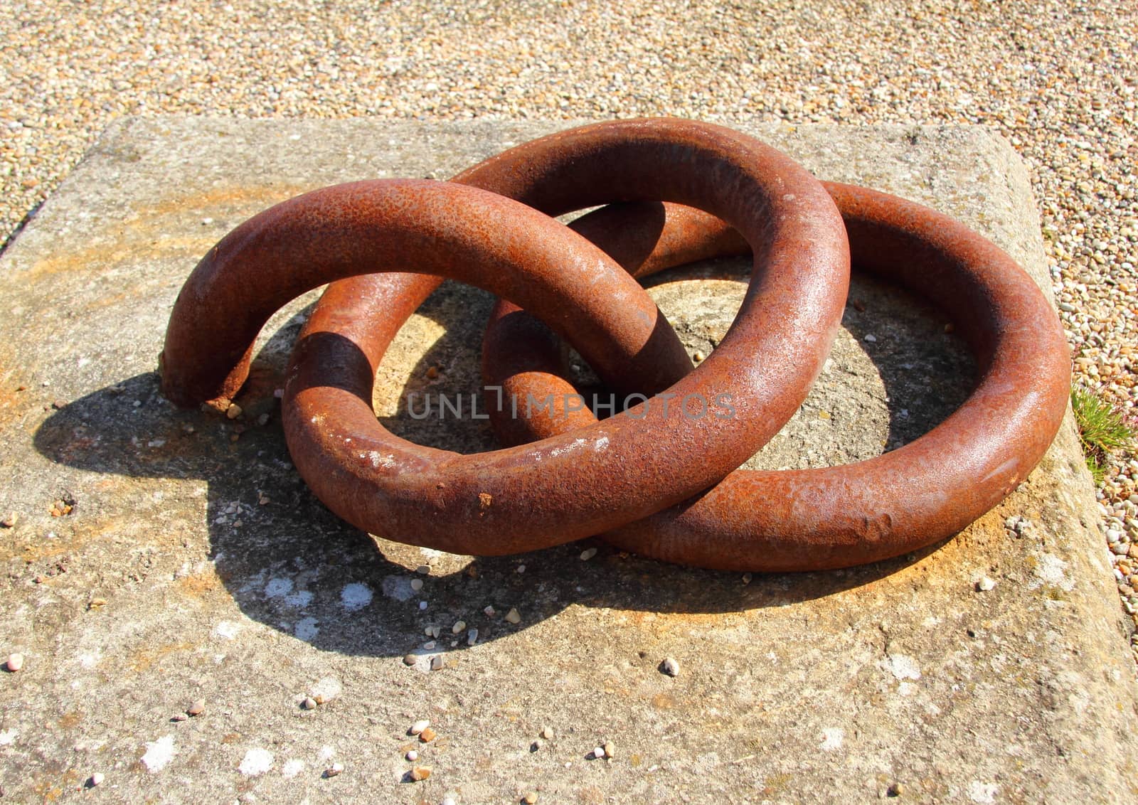 Two rusty metal bollard rings mounted to concrete block