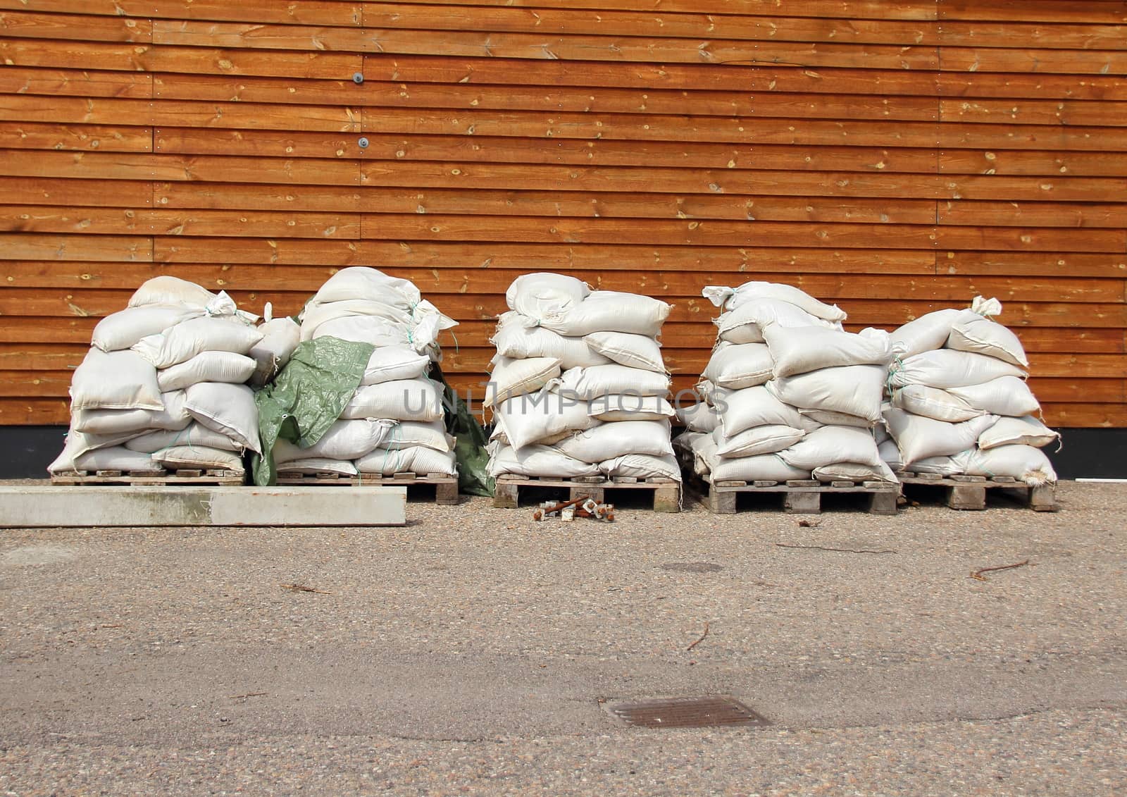Sandbags in five piles with wooden wall in background