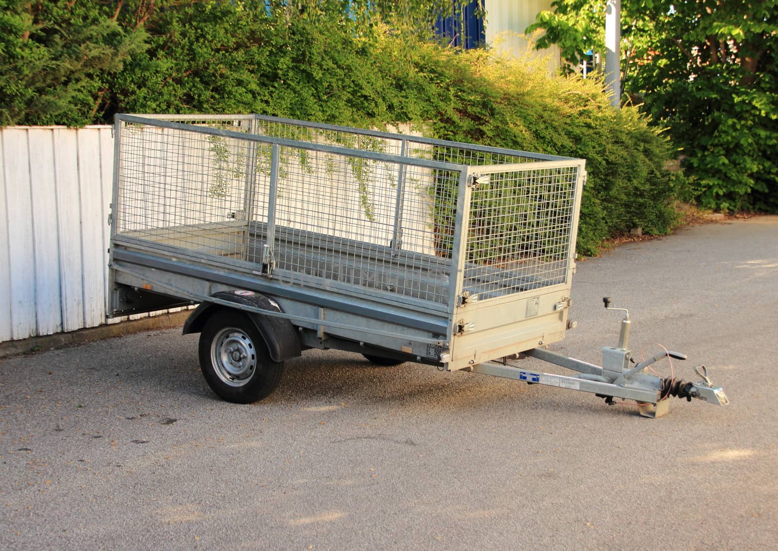 Trailer with metal net parked at white fence