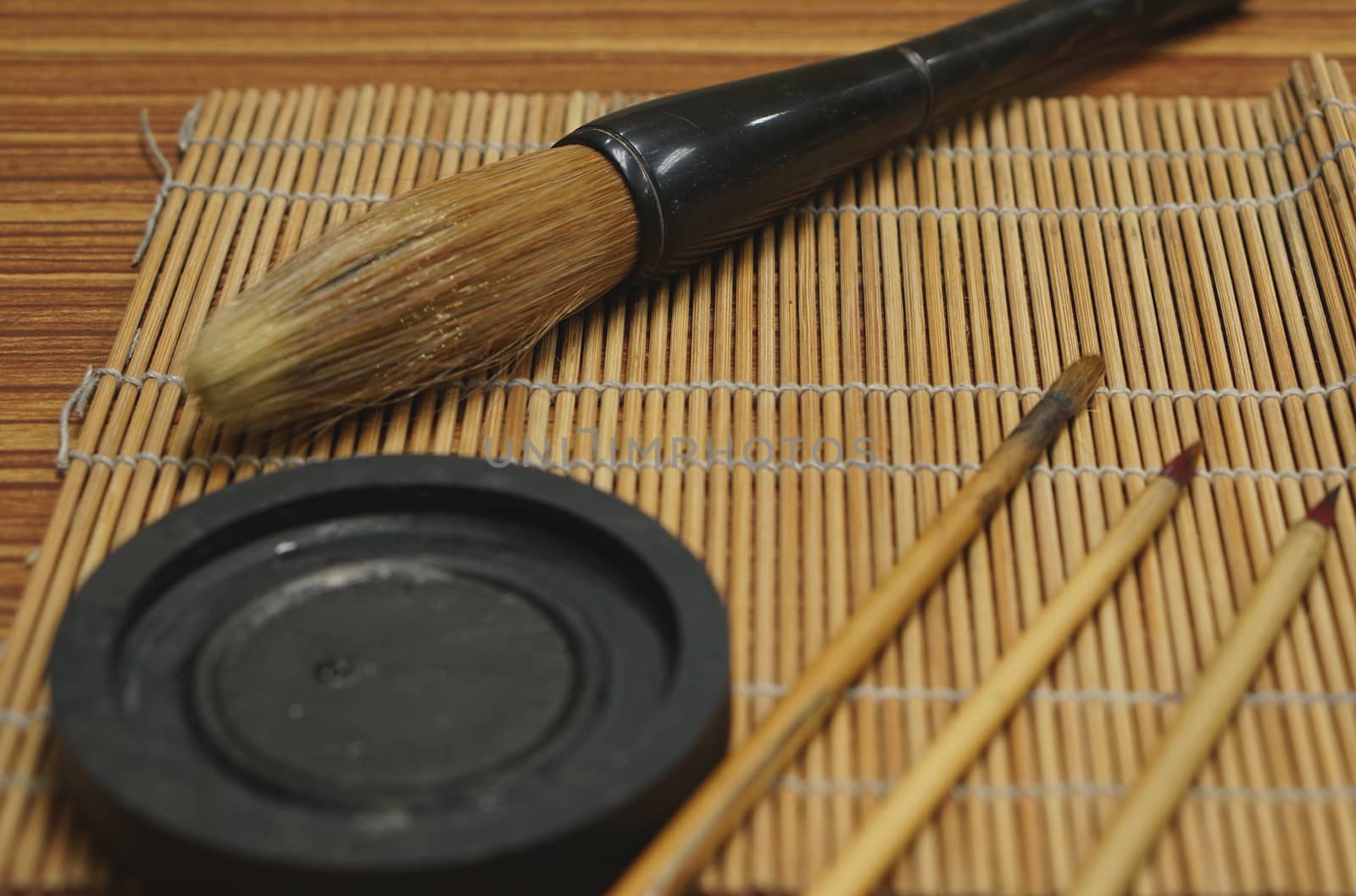 Chinese writing brush and ink stone on brush mat by ninun