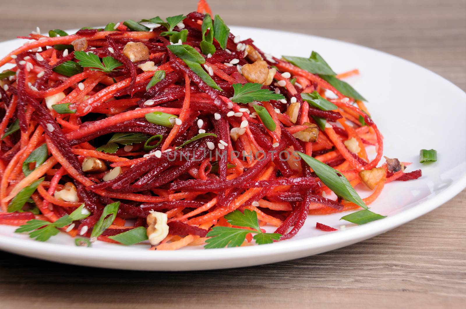 Salad of fresh grated carrots, beets, onions flavored with nuts and sesame seeds