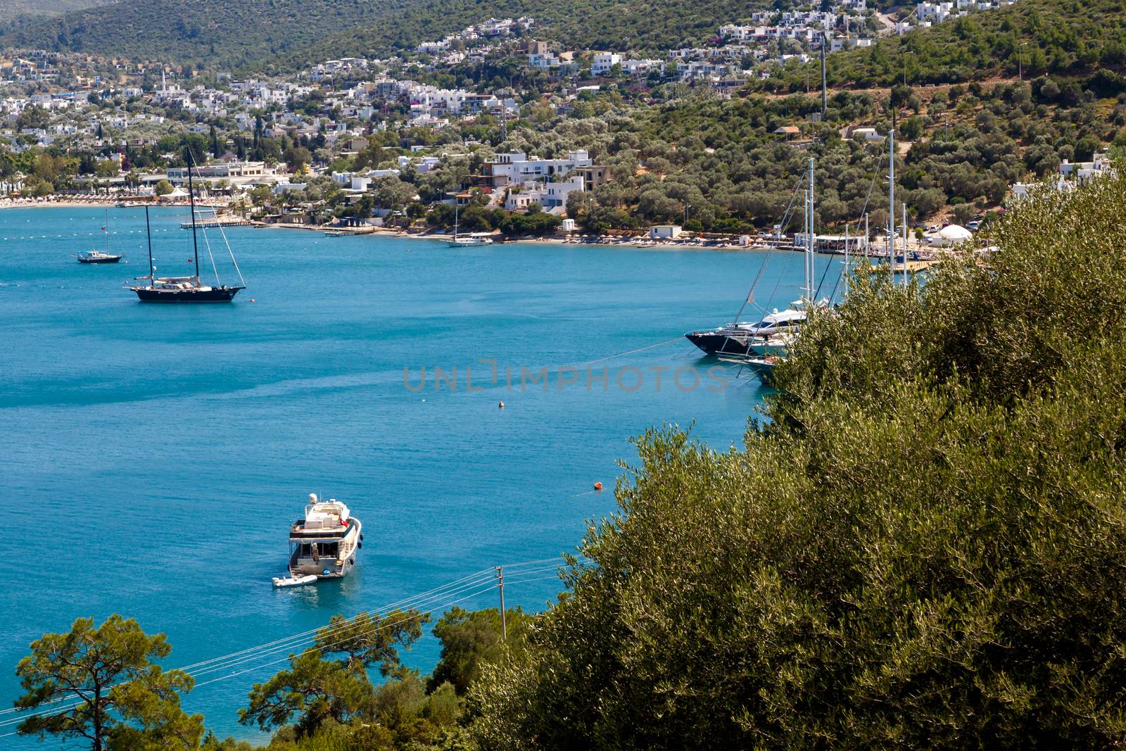 MUGLA, TURKEY - MAY28, 2016 : Seascape view of coastline with blue bright sea with small hills and small boats.