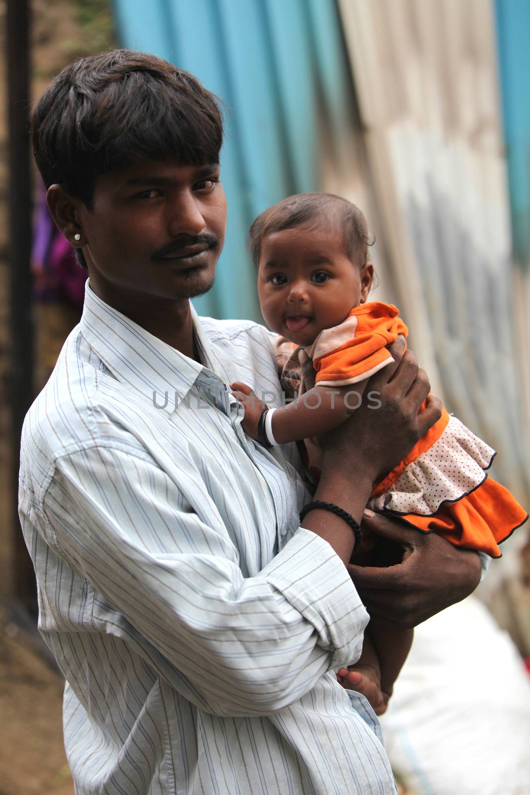 A portrait of a poor Indian father holding his little son, looking at him lovingly.