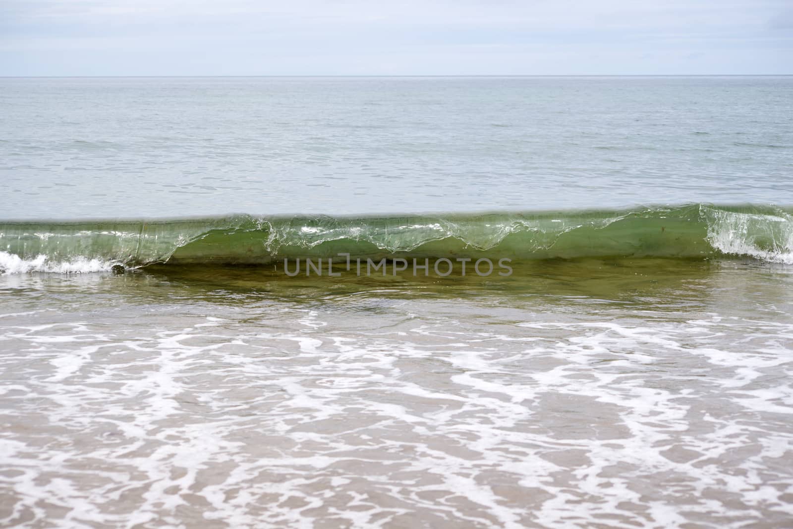 waves breaking on the beach in ballybunion by morrbyte