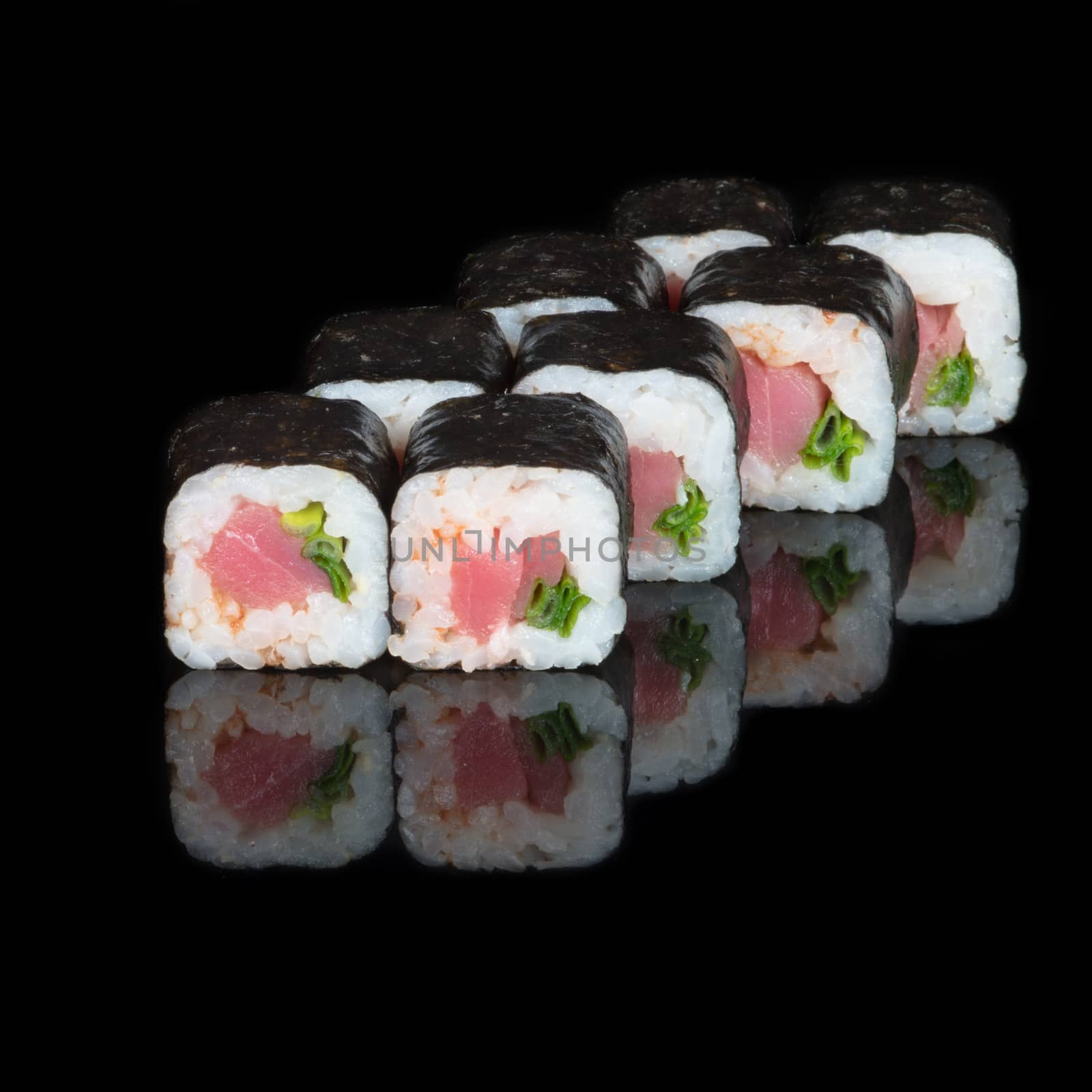 Sushi rolls with tuna and green onions on  black background
