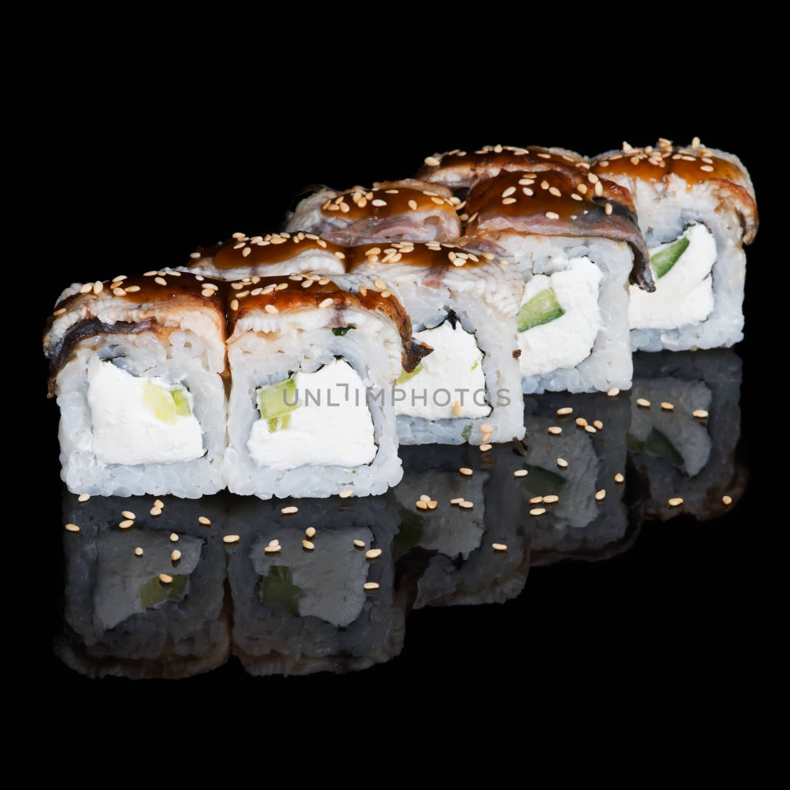 Sushi rolls with eel, cucumber and soft cheese on black background