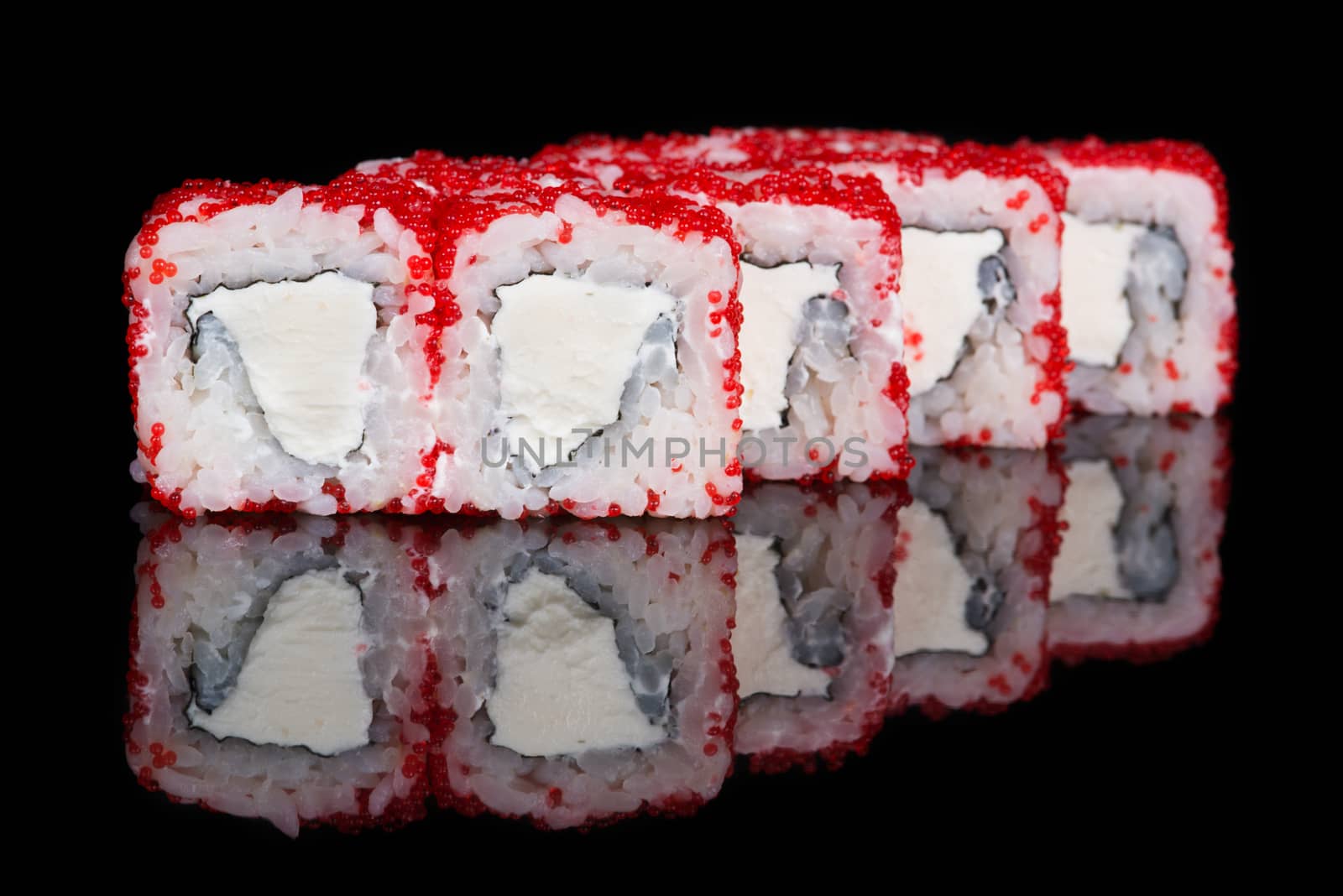 Sushi rolls with soft cheese and flying fish roe on black background