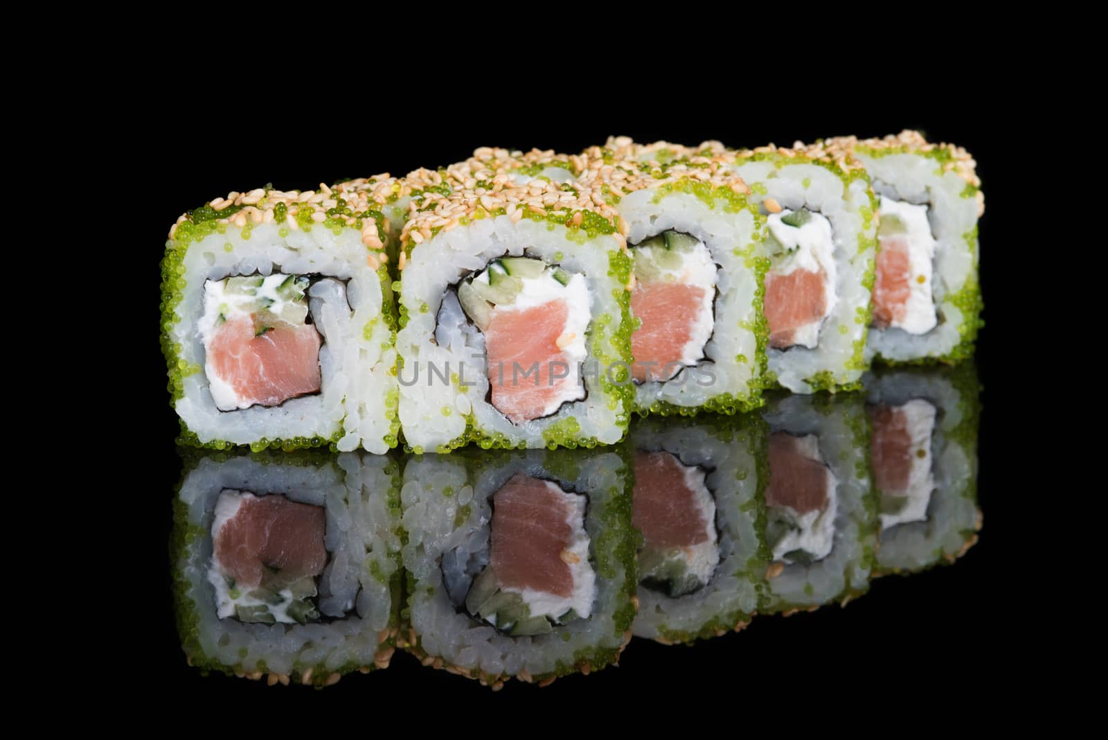 Sushi rolls with salmon, cucumber and flying fish roe on black background