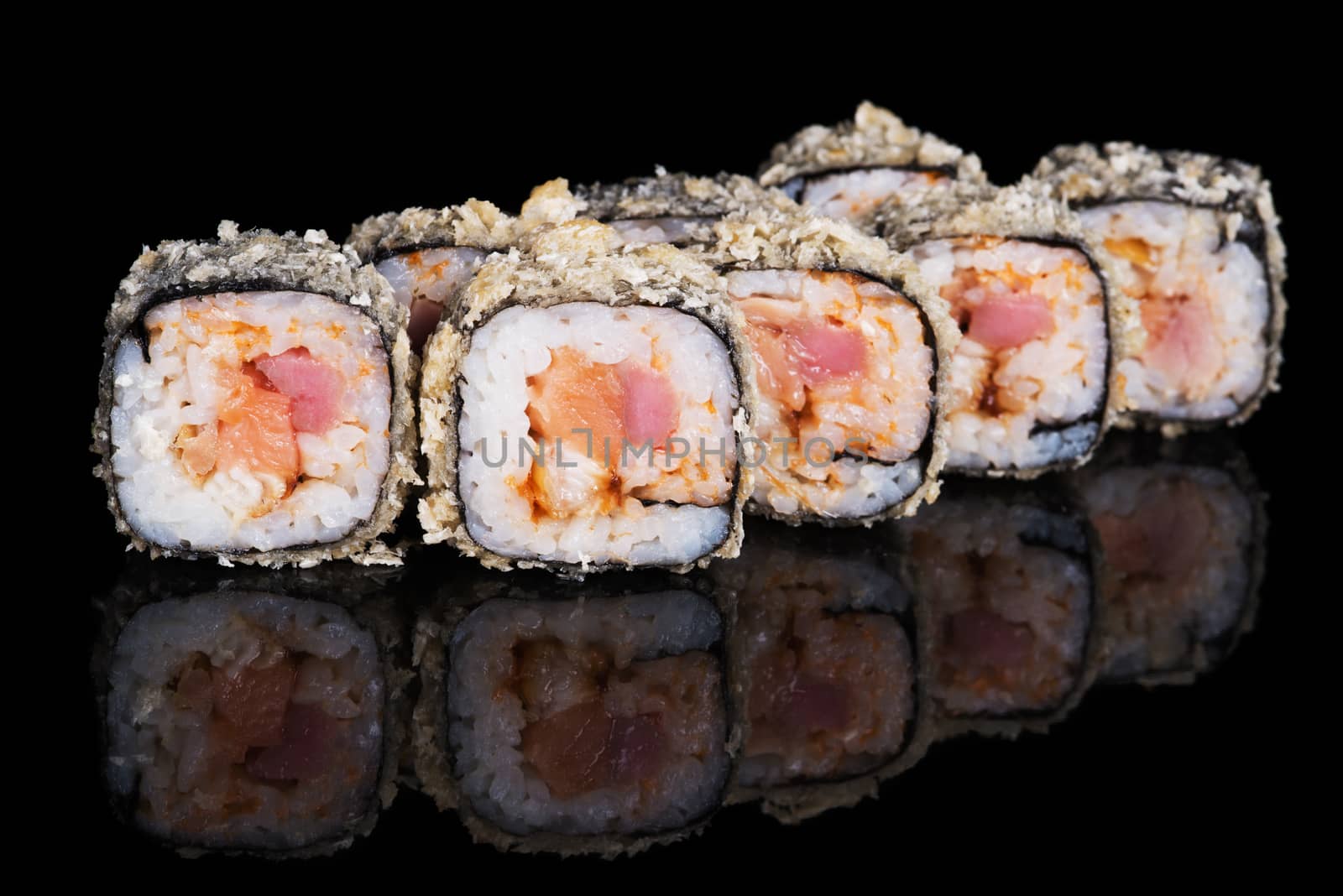 Grilled sushi rolls with fish and sause on  black background