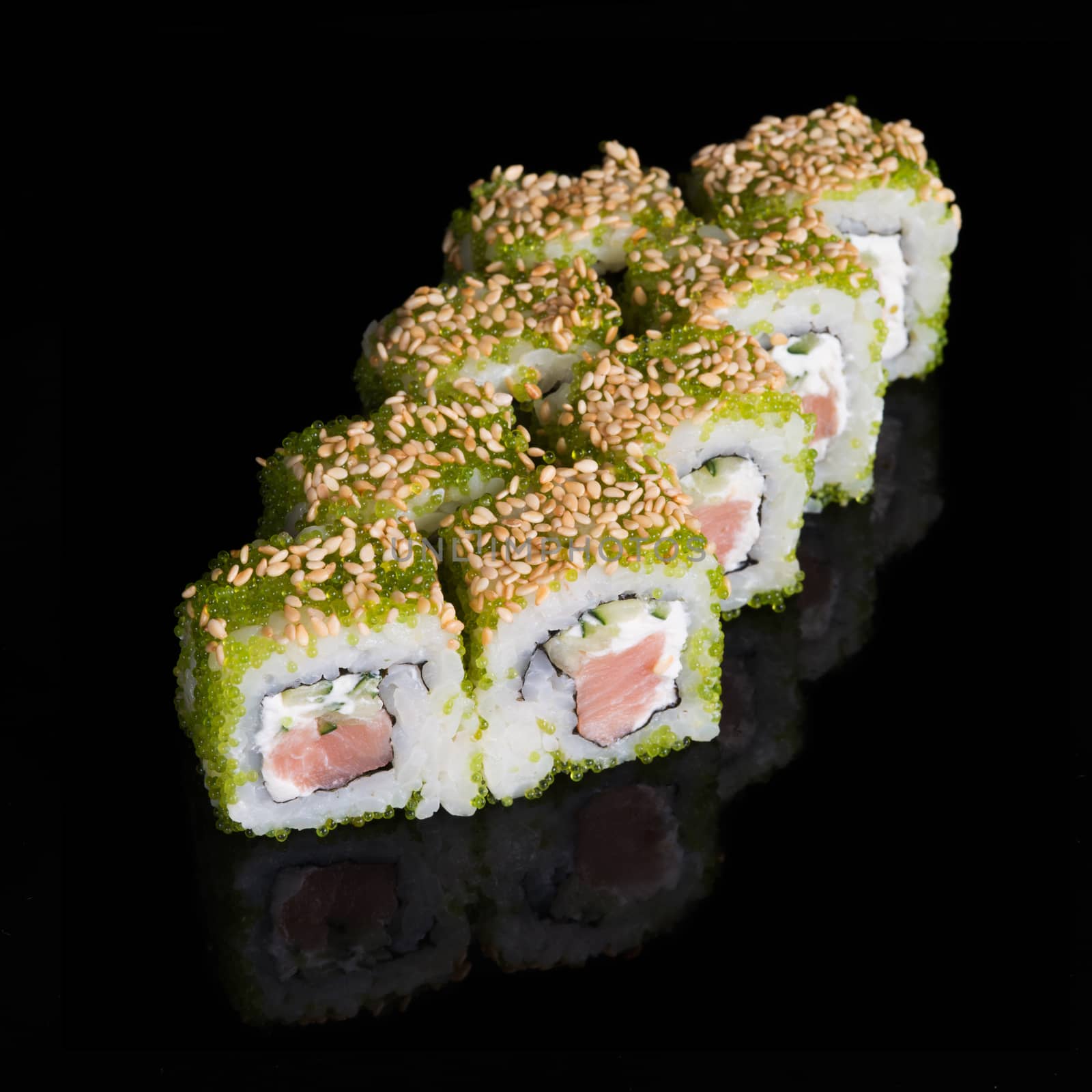 Sushi rolls with salmon, cucumber and flying fish roe on black background