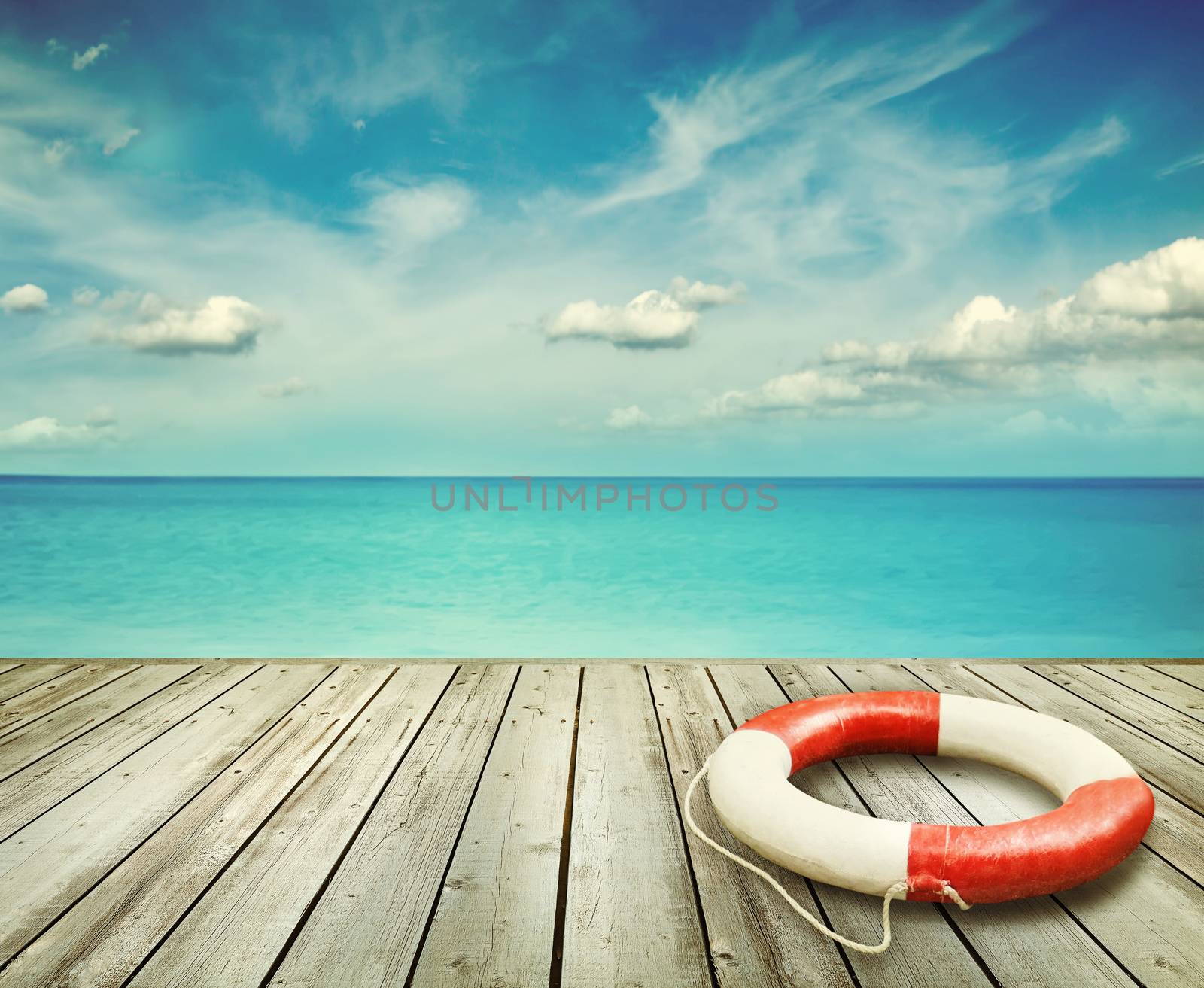 Wood pier with ocean and life preserver by Sandralise